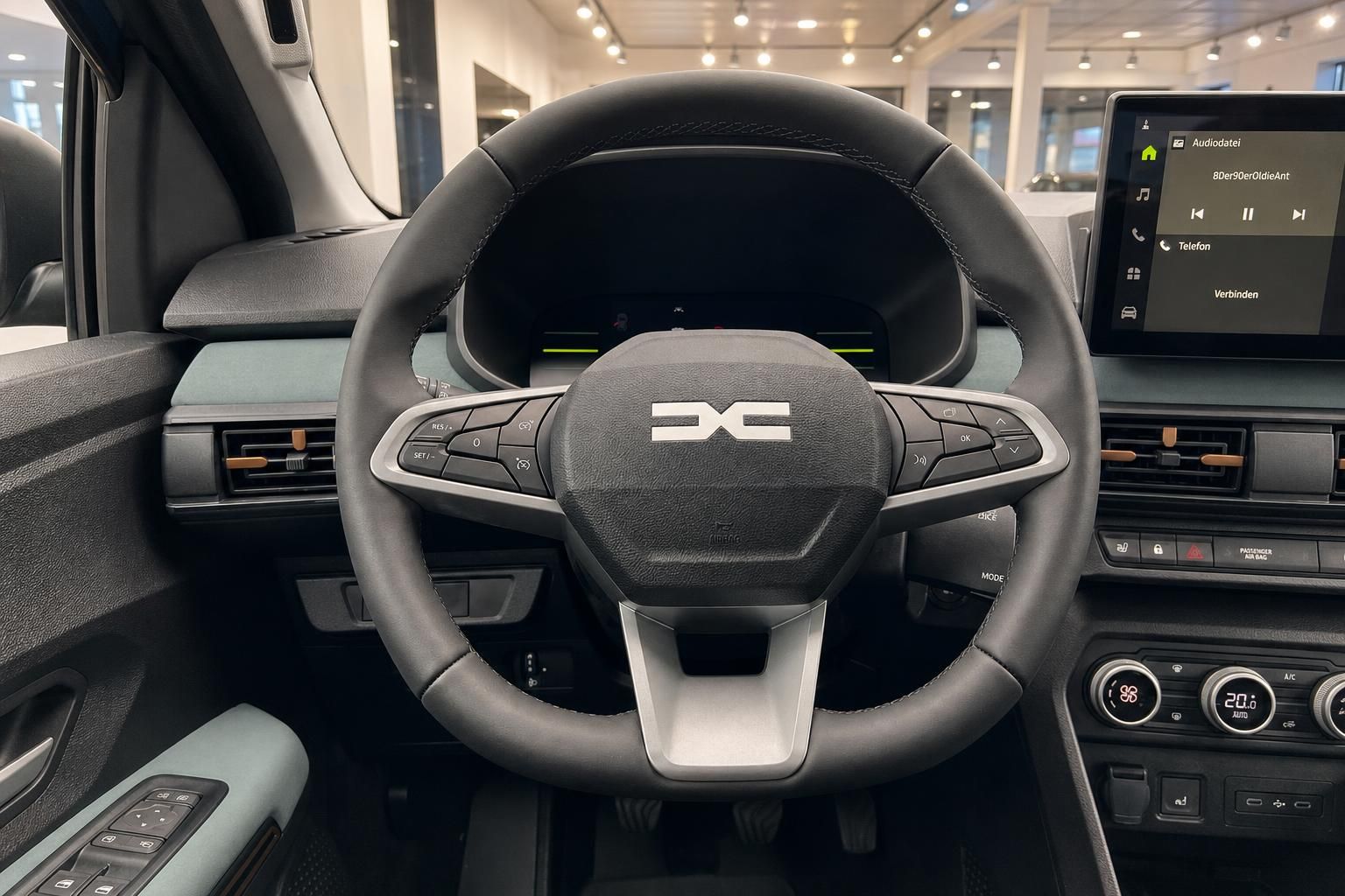 Lenkrad mit Multifunktionstasten und Infotainment-Display im Fahrzeuginnenraum