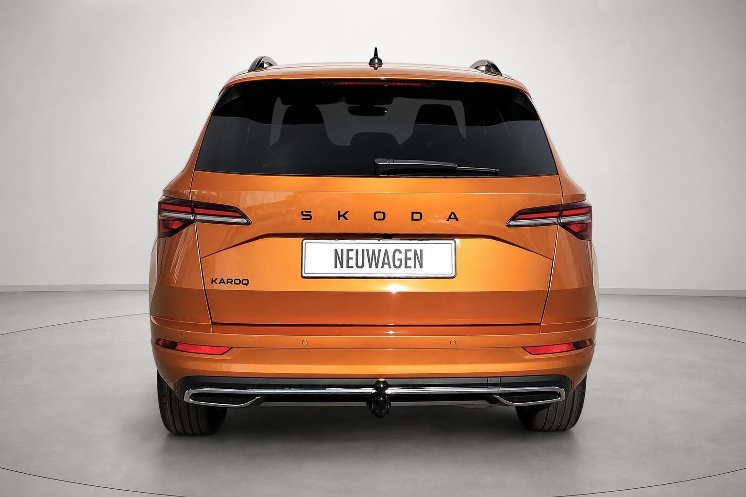 Skoda Karoq orange, Heckansicht mit Anhaengerkupplung im Studio