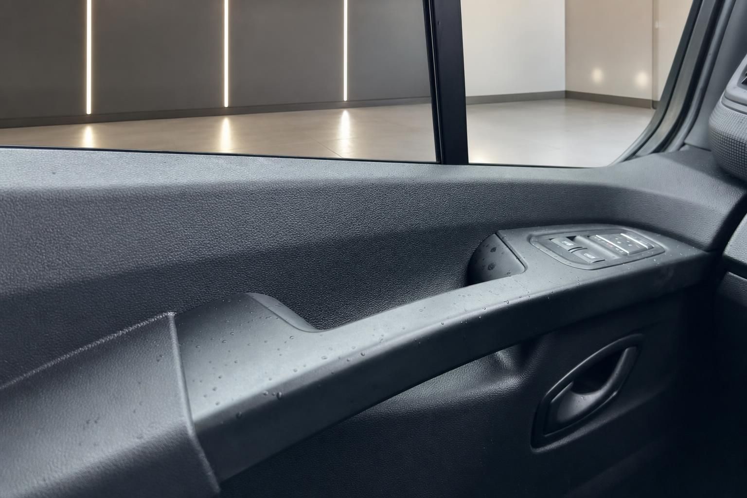 Fahrzeuginnenraum mit dunklem Armaturenbrett und Fensterheberschaltern