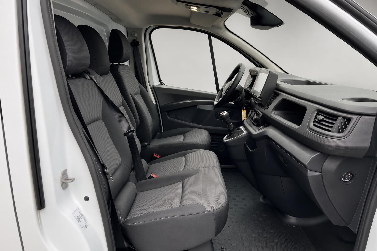 Innenraum eines weißen Transporters mit grauen Stoffsitzen und modernem Cockpit