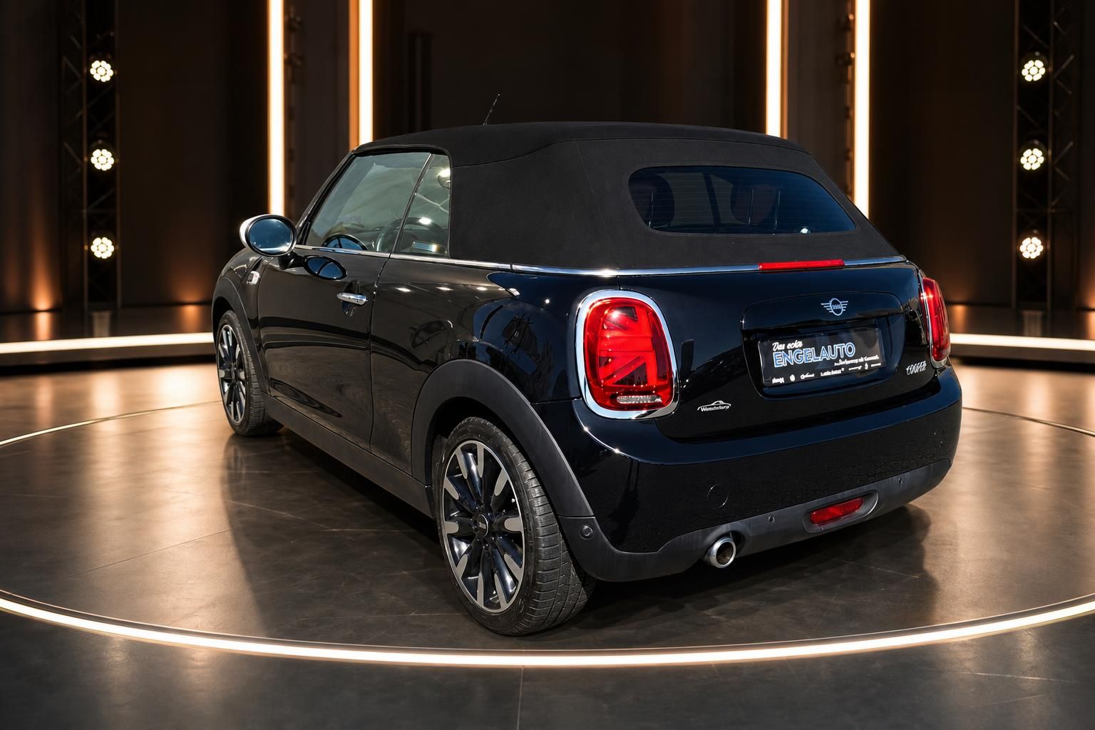 MINI Cooper Cabrio schwarz mit Softverdeck - Heckansicht mit Kennzeichen und roten Rückleuchten
