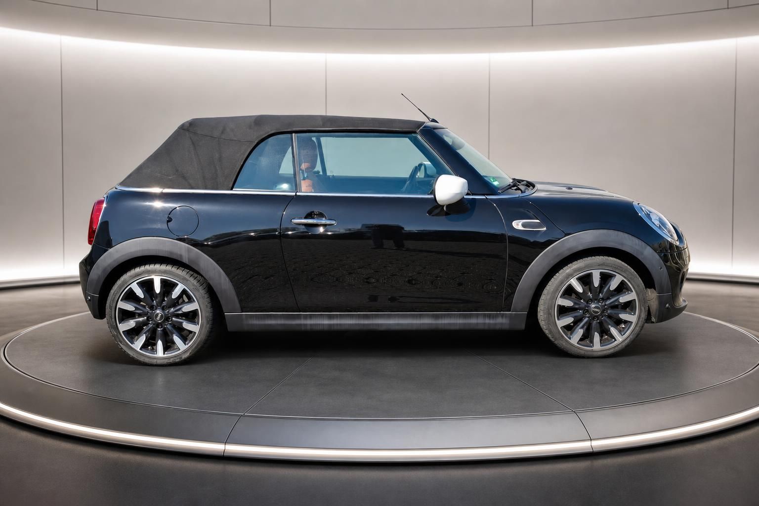 MINI Cooper Cabrio in Midnight Black mit Stoffverdeck - Seitenansicht im Showroom