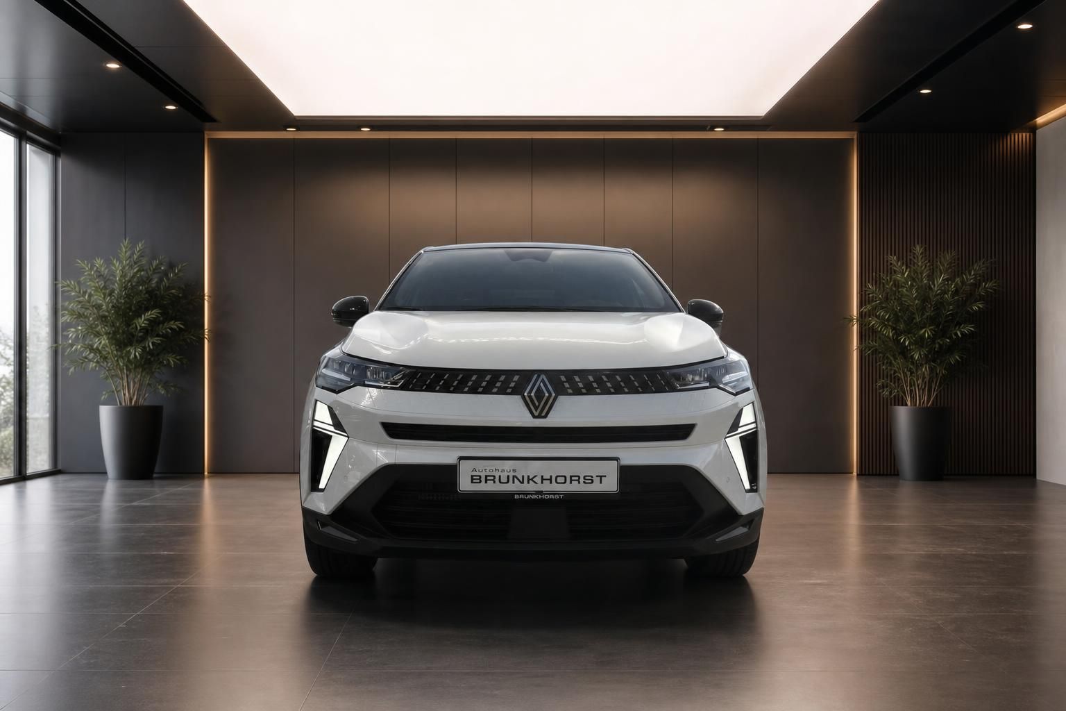 Renault Captur weißer Elektro-SUV Frontansicht in elegantem Showroom mit Pflanzen