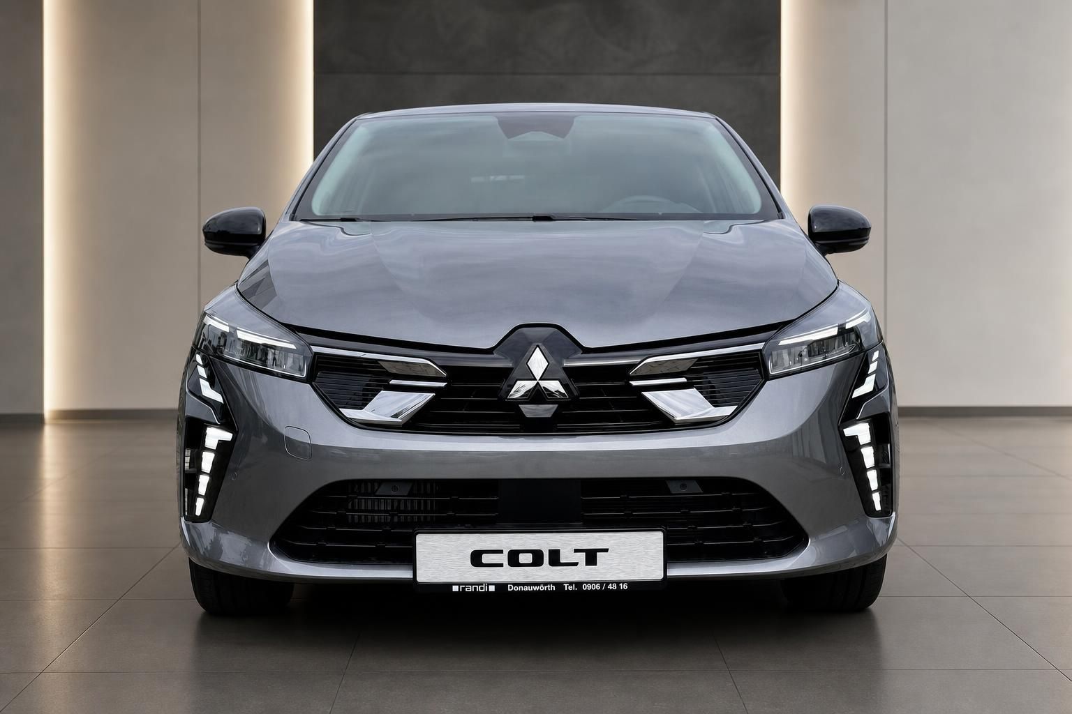 Mitsubishi Colt grau Frontansicht im Showroom – modernes Design mit LED-Scheinwerfern