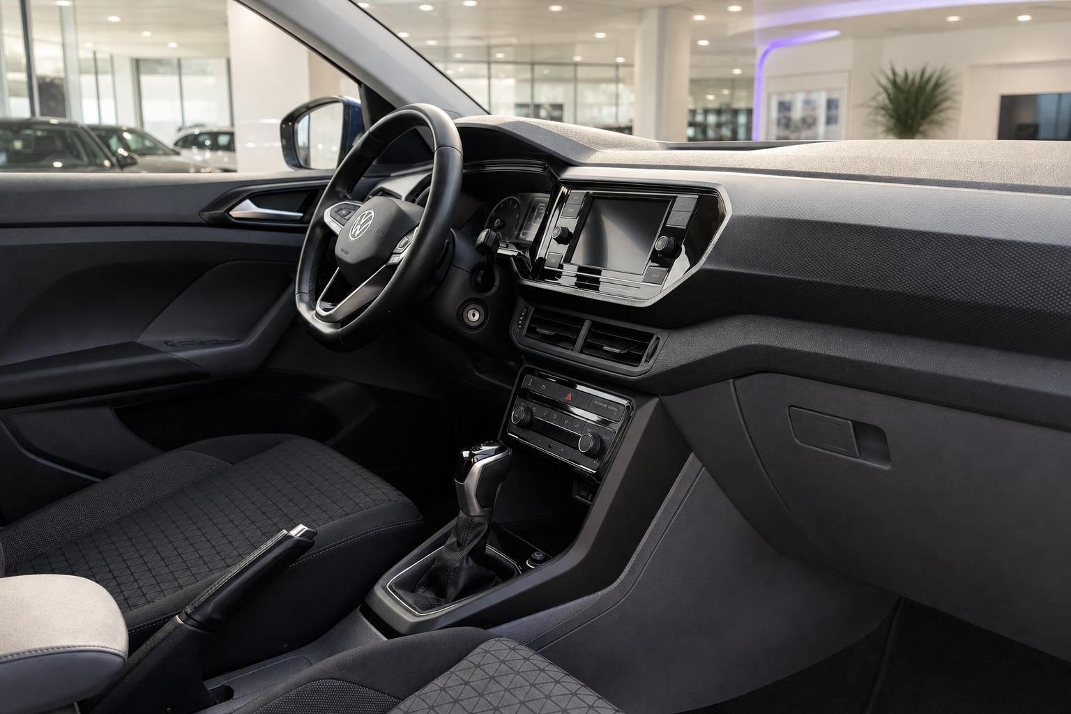 VW Innenraum mit Cockpit, Lenkrad und Multimedia-Display im Autohaus