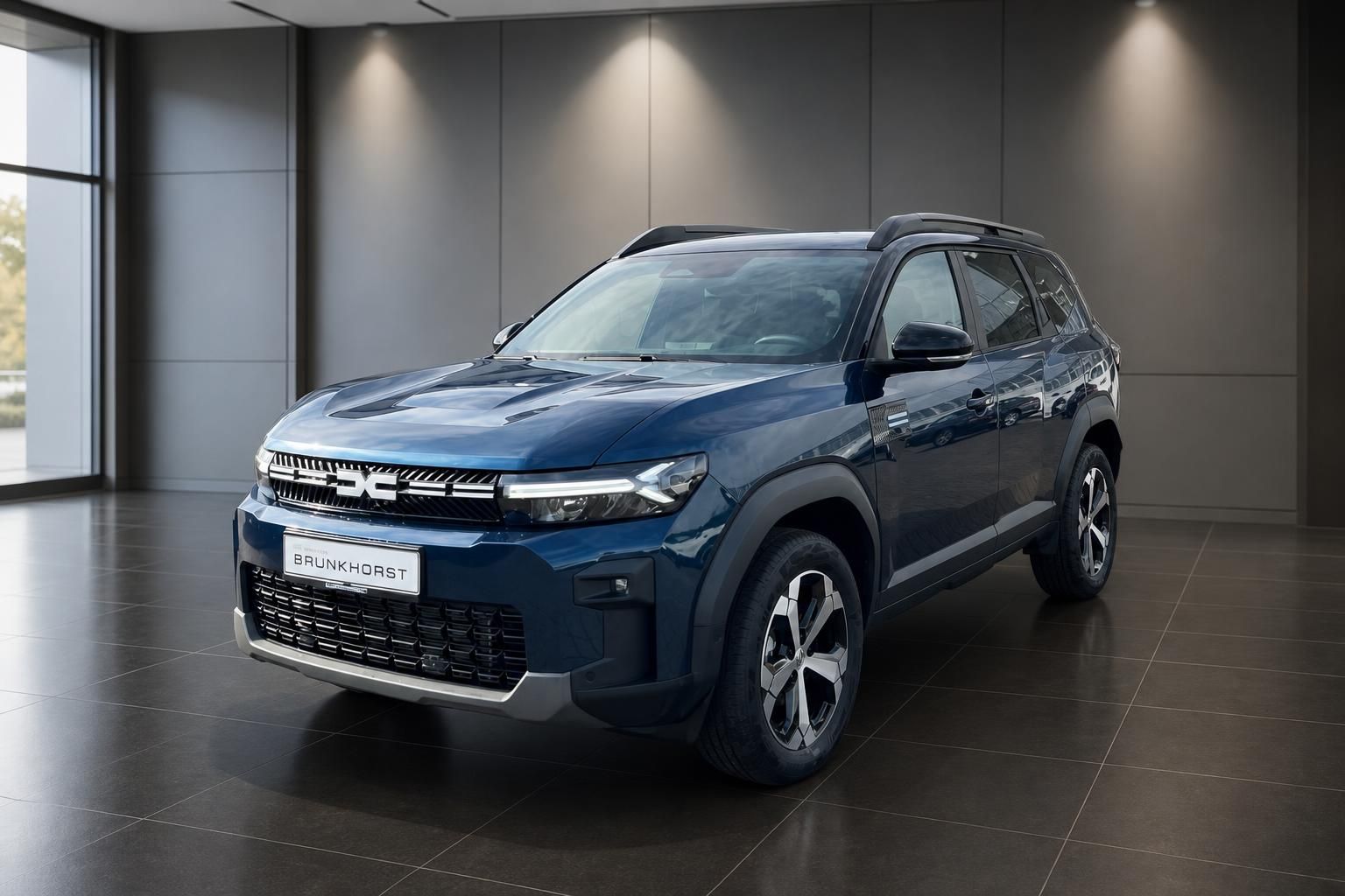 Dacia Bigster SUV in blau, Frontansicht im Showroom - modernes Design mit LED-Scheinwerfern