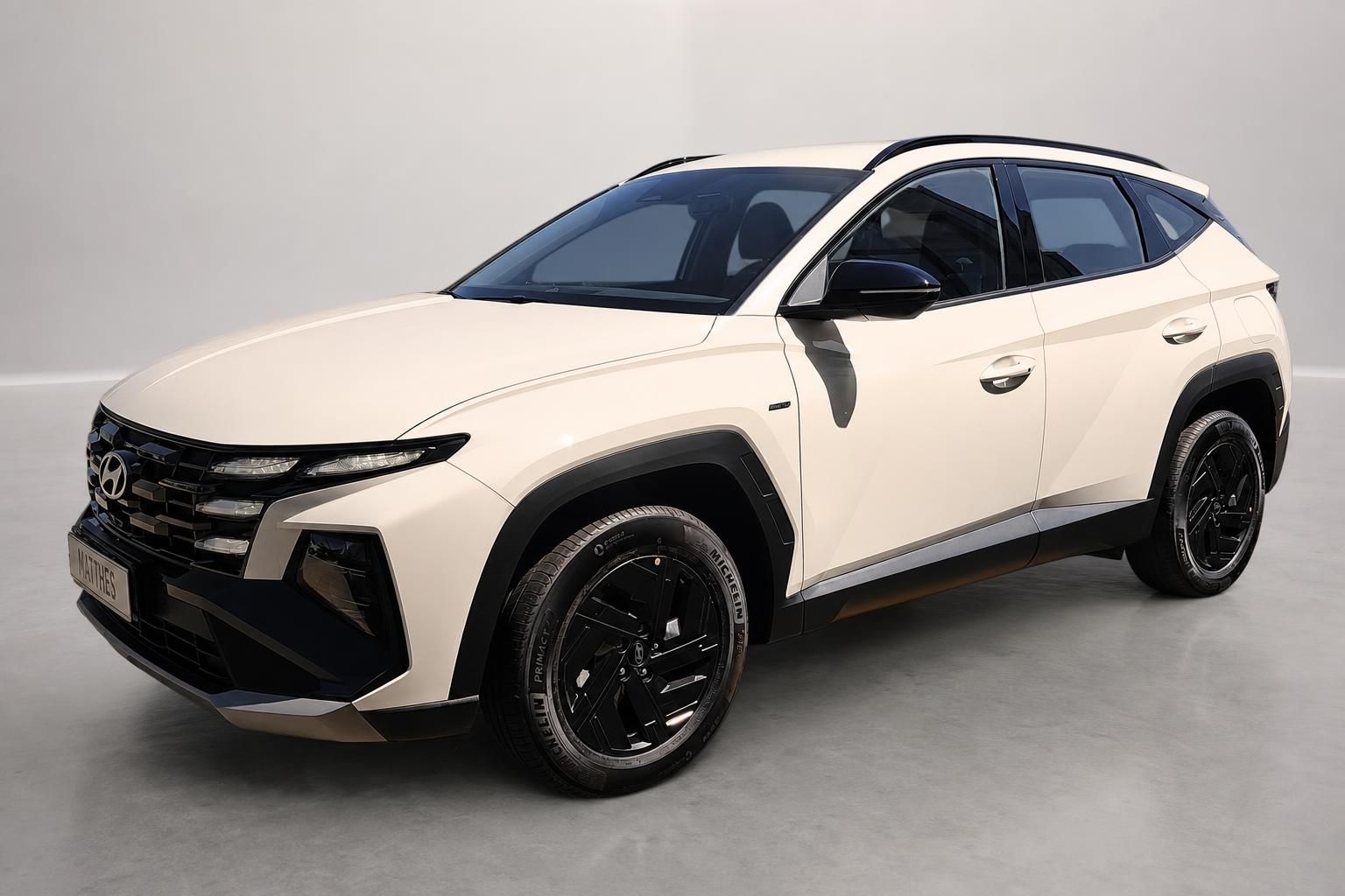 Hyundai Tucson SUV in Creme-Weiß, Frontansicht schräg im Studio