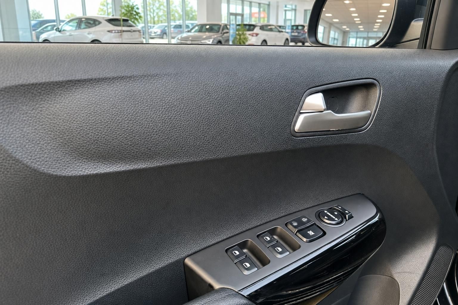 Tuerverkleidung mit Fensterhebern und Griff im Kia Innenraum