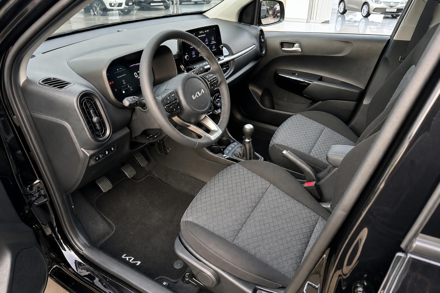 Kia Picanto Innenraum – Blick auf Fahrersitz, Lenkrad und Armaturenbrett