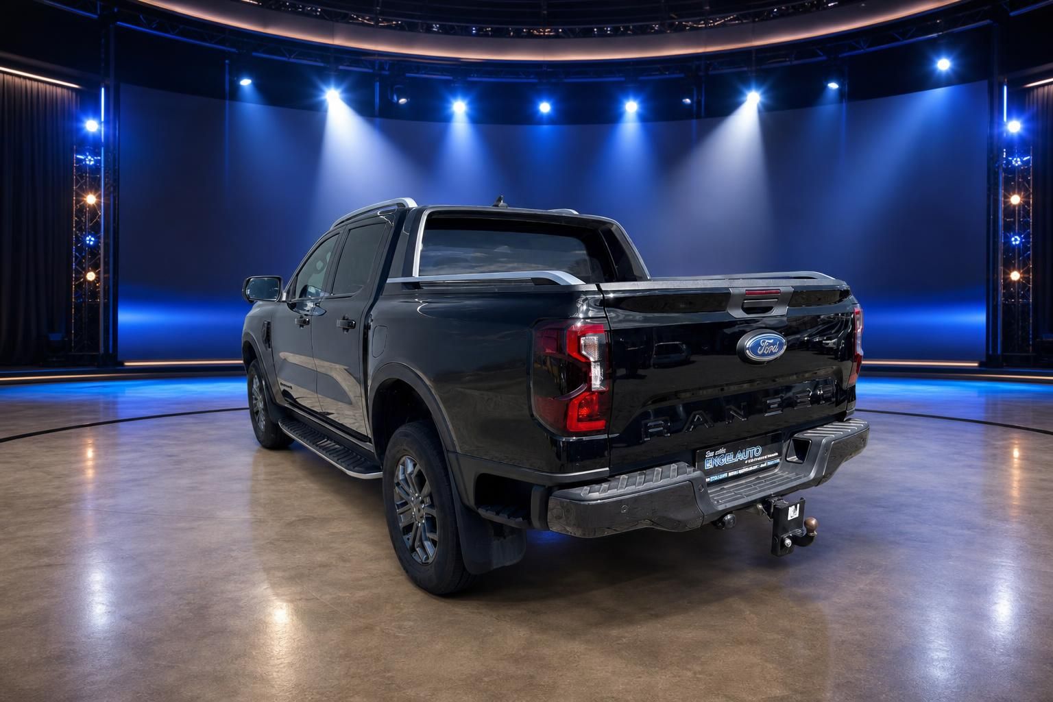 Ford Ranger Pickup-Truck schwarz Heckansicht mit Anhängerkupplung in blau beleuchtetem Showroom