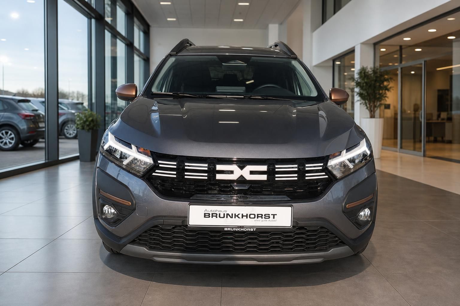 Dacia SUV Frontansicht grau metallic mit LED-Scheinwerfern und schwarzem Kühlergrill