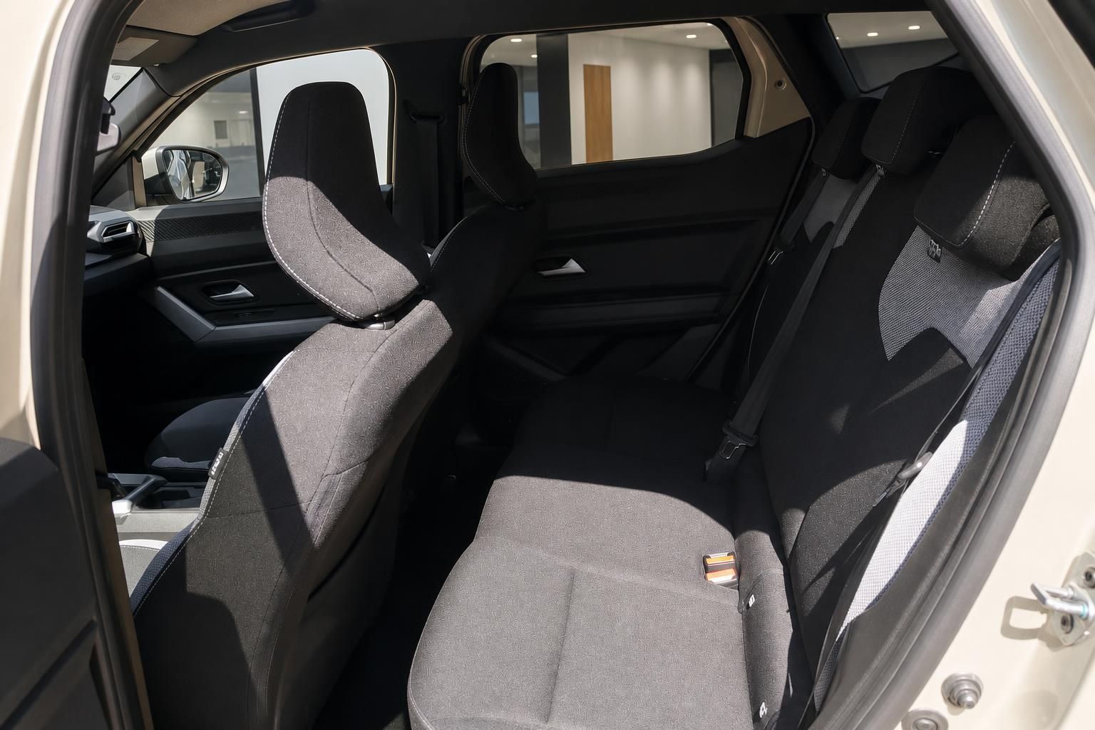 Dacia Rücksitzbank grau-schwarz mit Sicherheitsgurten und Blick auf Vordersitze im Autohaus