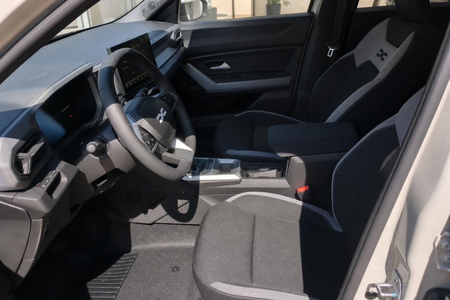Dacia Duster Hybrid Innenraum Fahrerseite mit Lenkrad, Sitzen und Cockpit