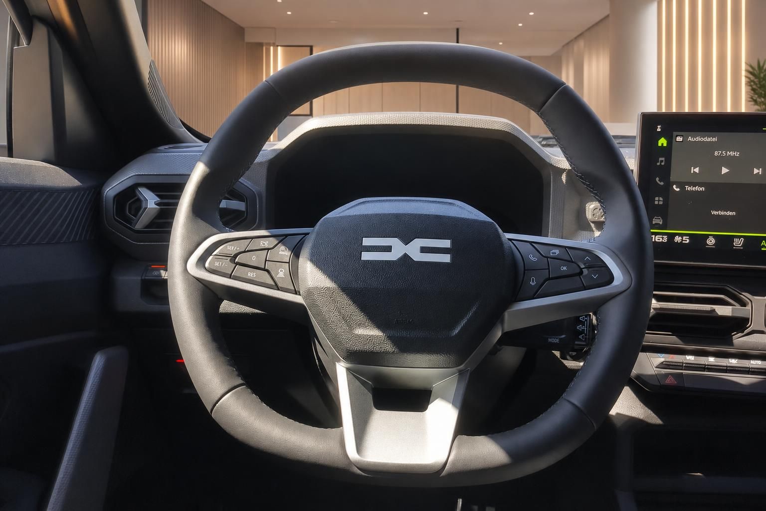 Dacia Innenraum Lenkrad mit Logo und Multifunktionstasten sowie digitalem Infotainment-Display