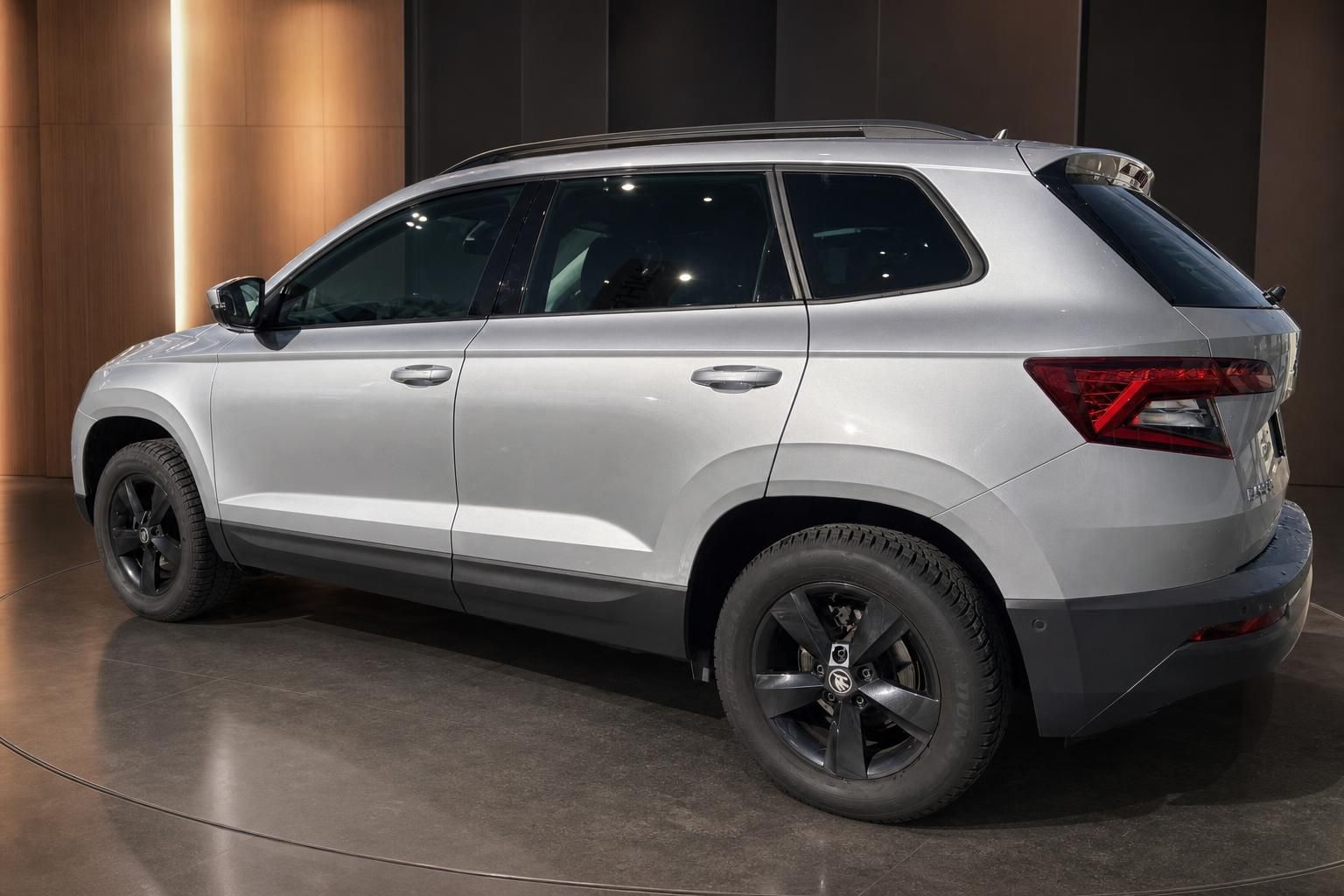 Skoda Karoq Seitenansicht in Silber mit schwarzen Felgen im Showroom