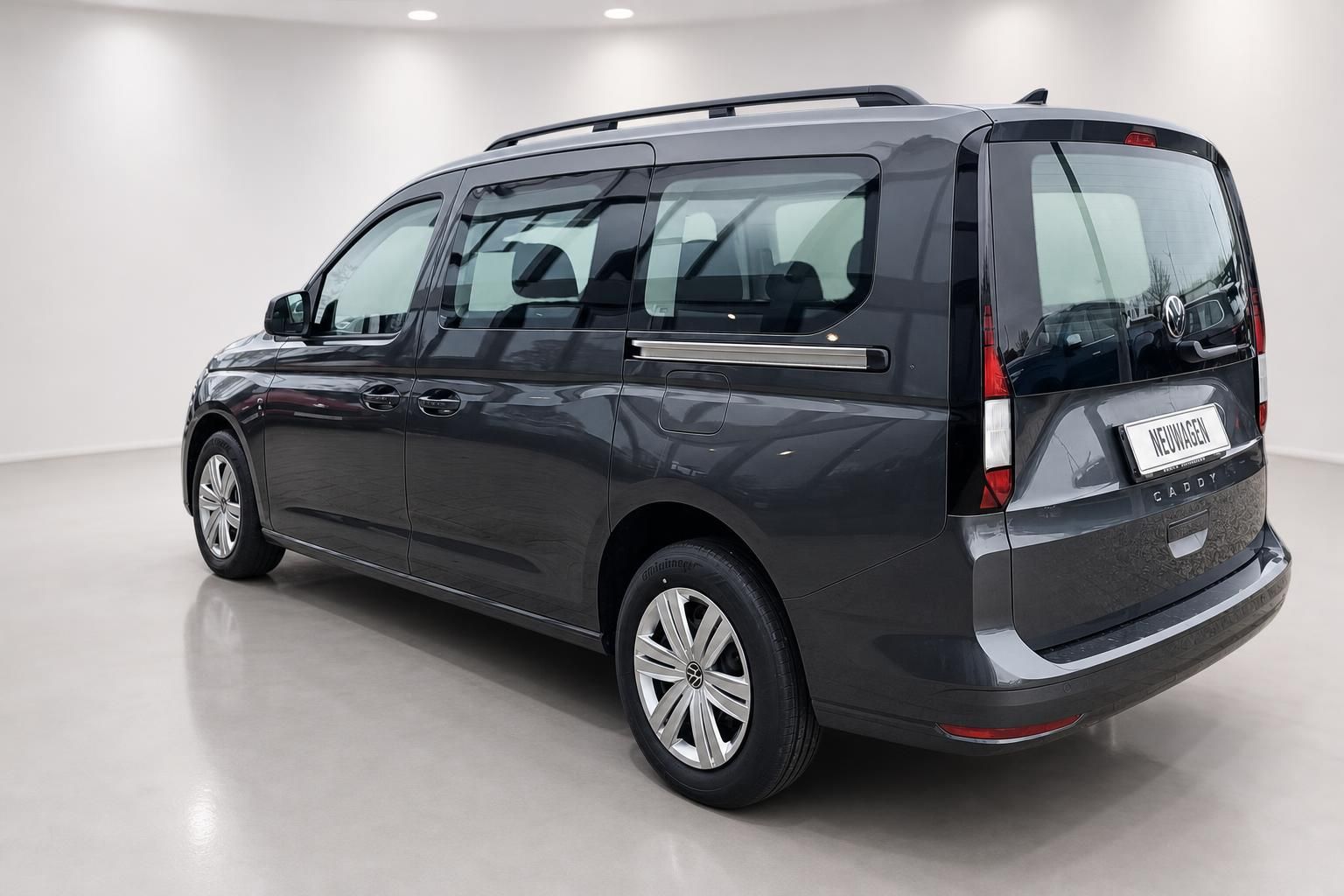 VW Caddy Heckansicht schräg, grauer Van mit Kennzeichenhalter