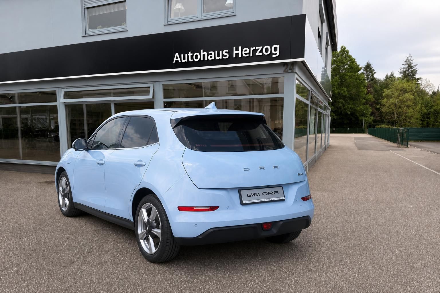 GWM ORA Elektroauto hellblau Heckansicht seitlich vor Autohaus Herzog