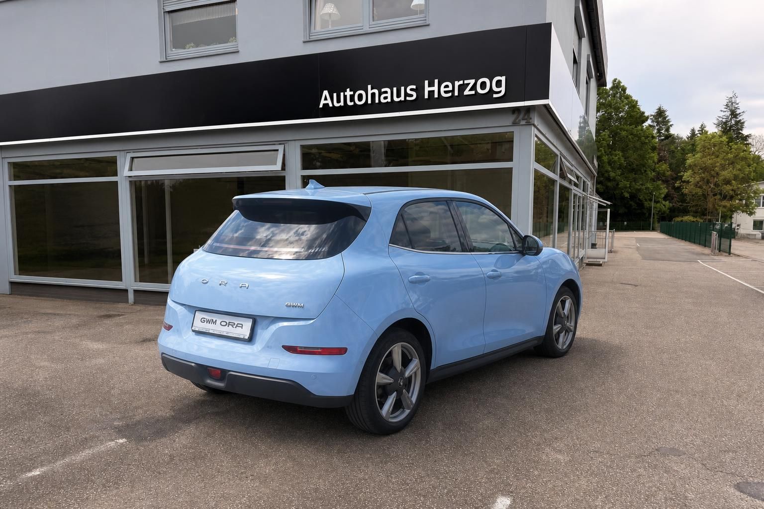 Hellblaues GWM ORA Elektrofahrzeug Heckansicht seitlich bei Autohaus Herzog