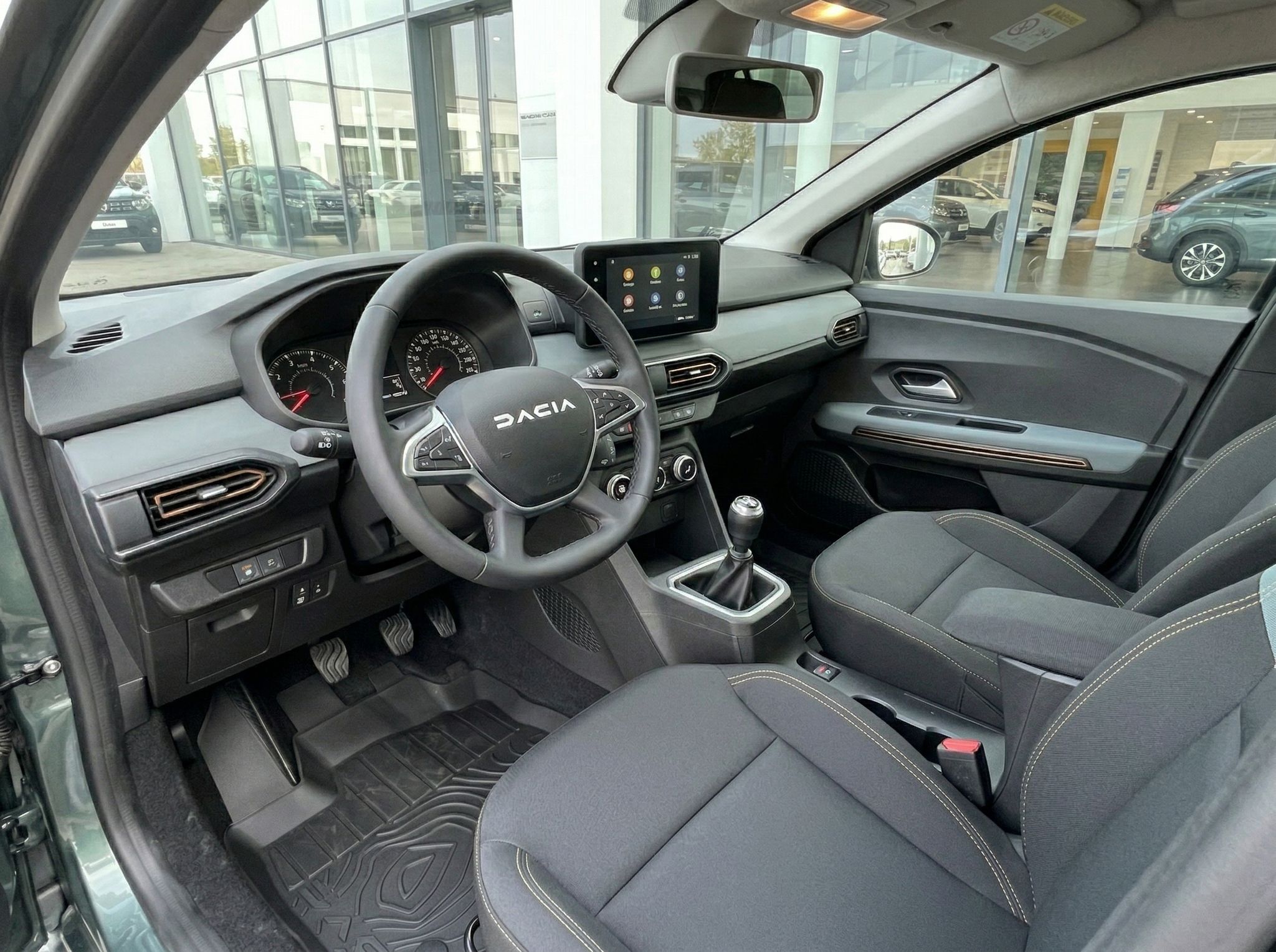 Dacia Innenraum mit schwarzer Ausstattung, Lenkrad und Touchscreen Display