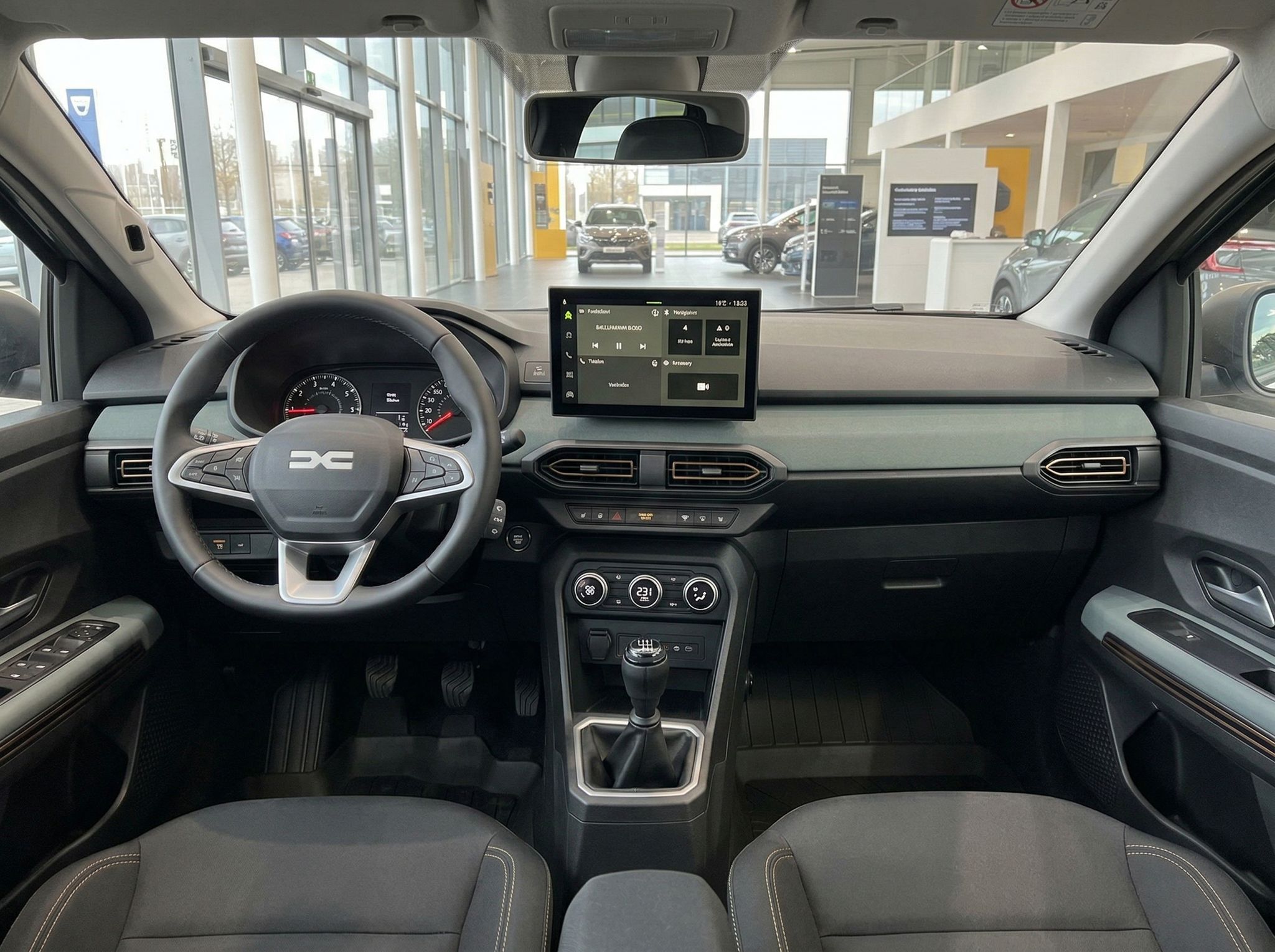 Innenraum eines Fahrzeugs mit Lenkrad, Armaturenbrett und Touchscreen-Display