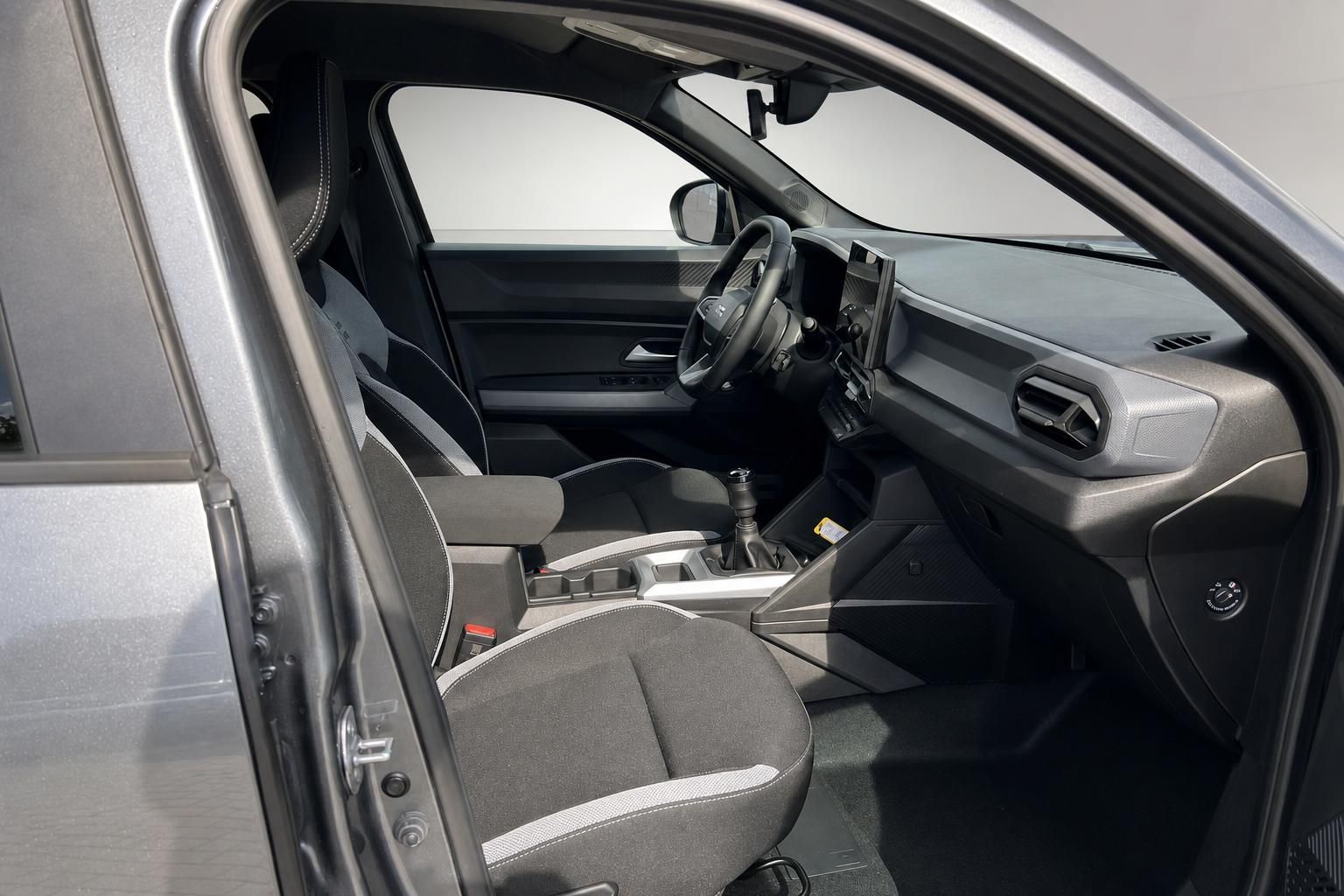 Blick ins Fahrzeuginterieur mit Armaturenbrett, Lenkrad und Vordersitzen