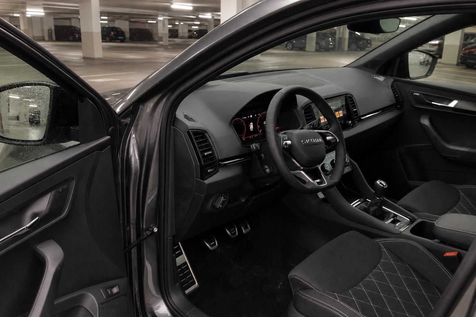 Skoda Karoq Innenraum Fahrerseite mit Lenkrad, Cockpit und schwarzen Sitzen