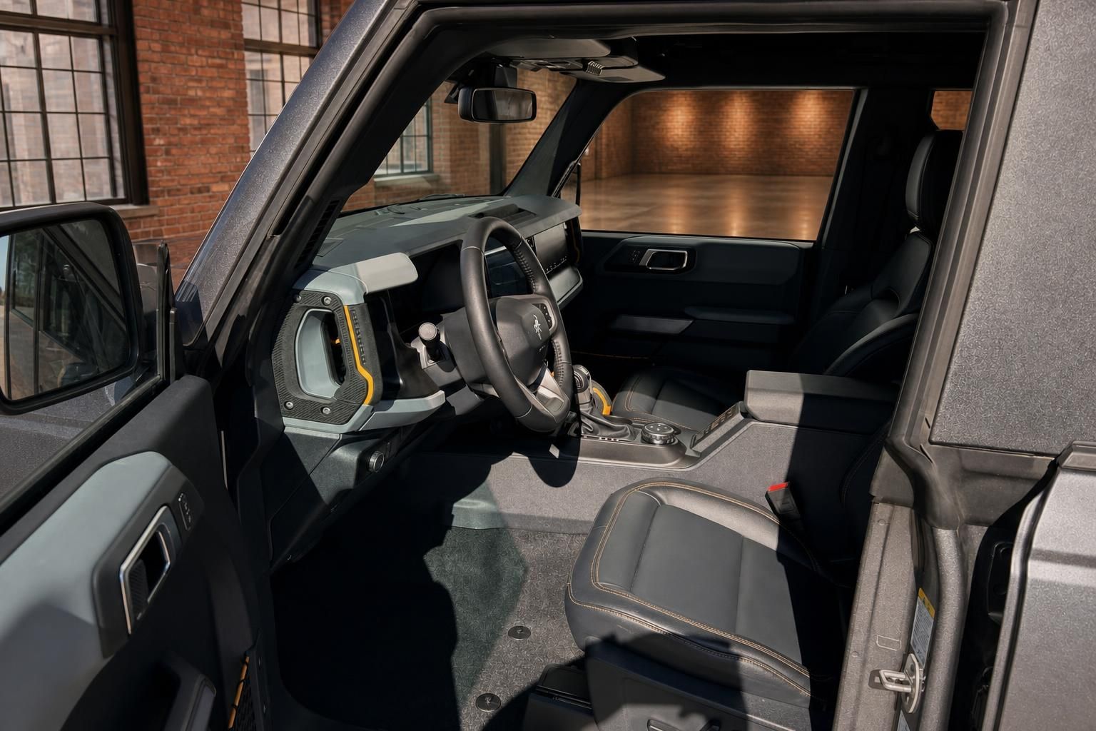 Ford Bronco Innenraum mit schwarzem Leder, Sportlenkrad und orangefarbenen Kontrastnähten