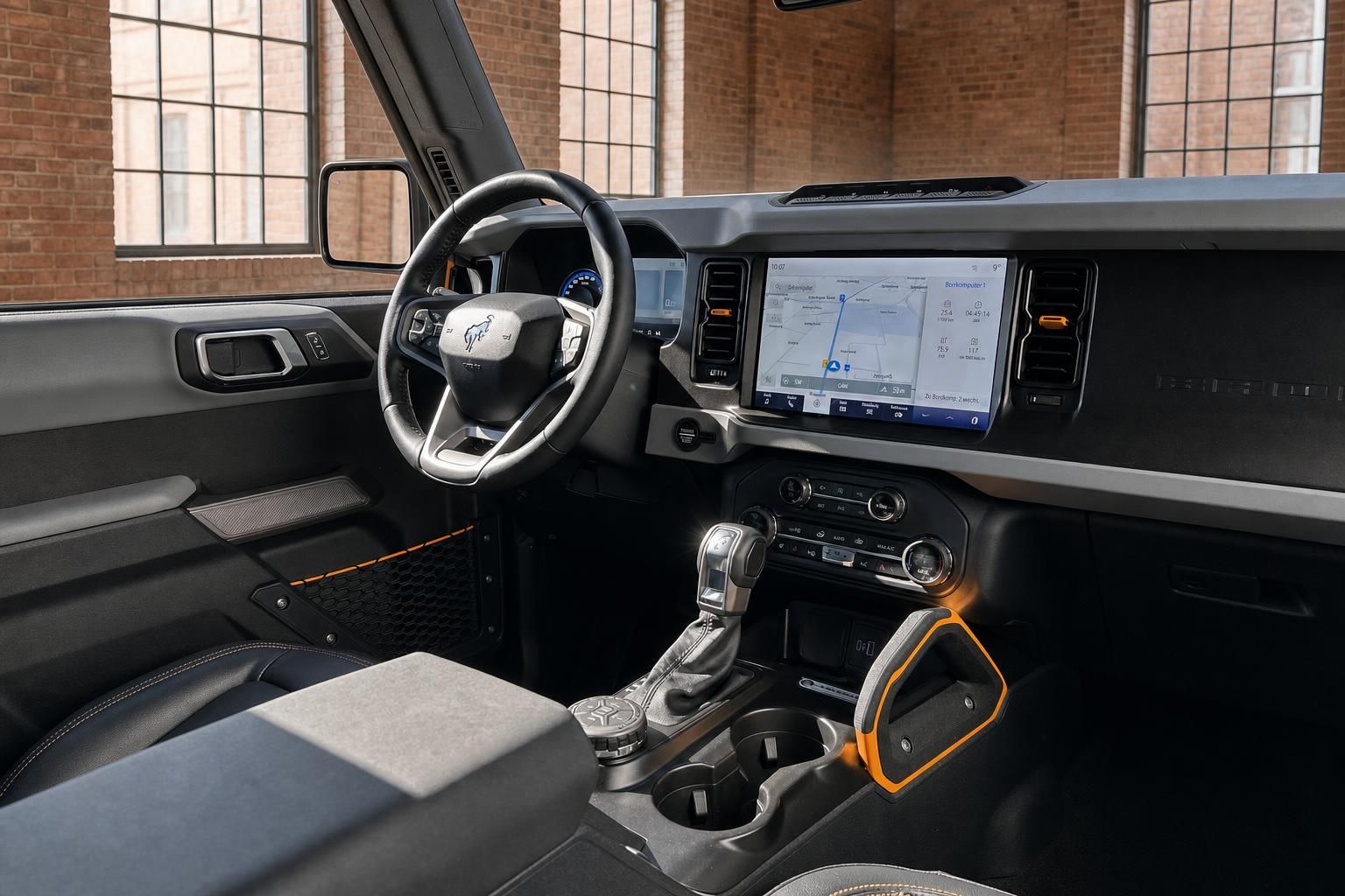 Ford Bronco Cockpit mit großem Touchscreen-Navigationssystem und Lenkrad mit Mustang-Logo