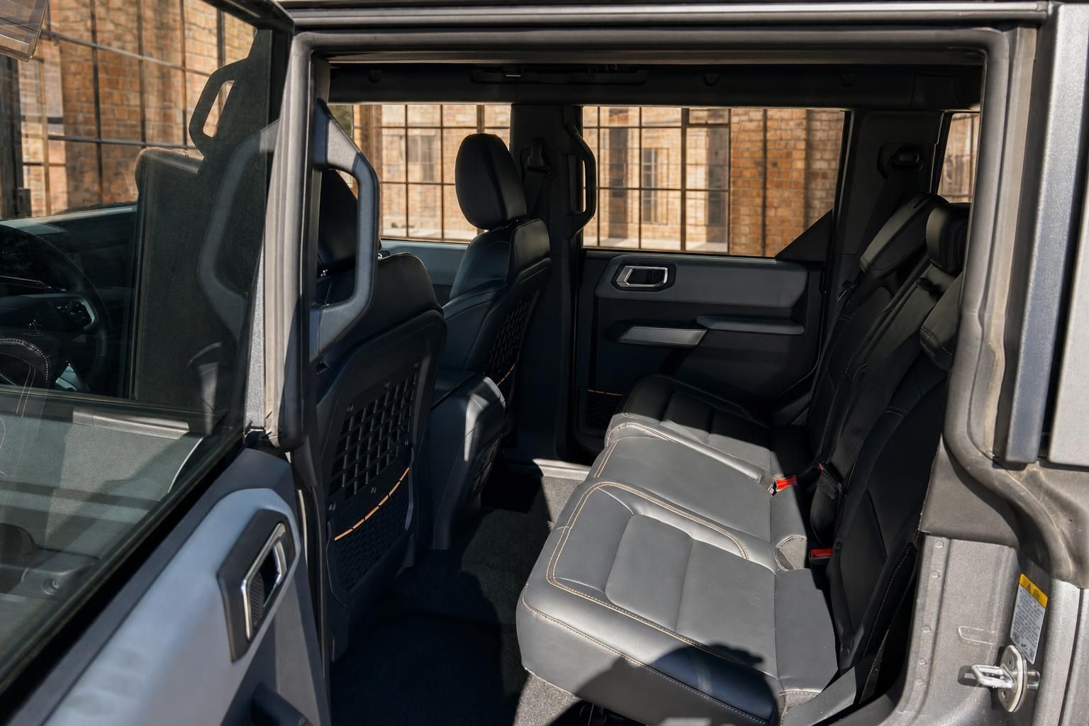 Ford Bronco Rücksitzbereich mit grauen Ledersitzen und geöffneter Hecktür von außen