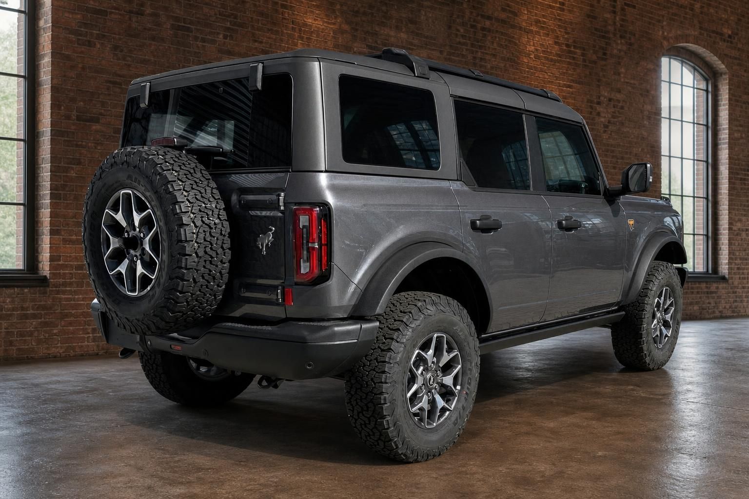 Ford Bronco grau Heckansicht schräg links mit Reserverad und Geländereifen