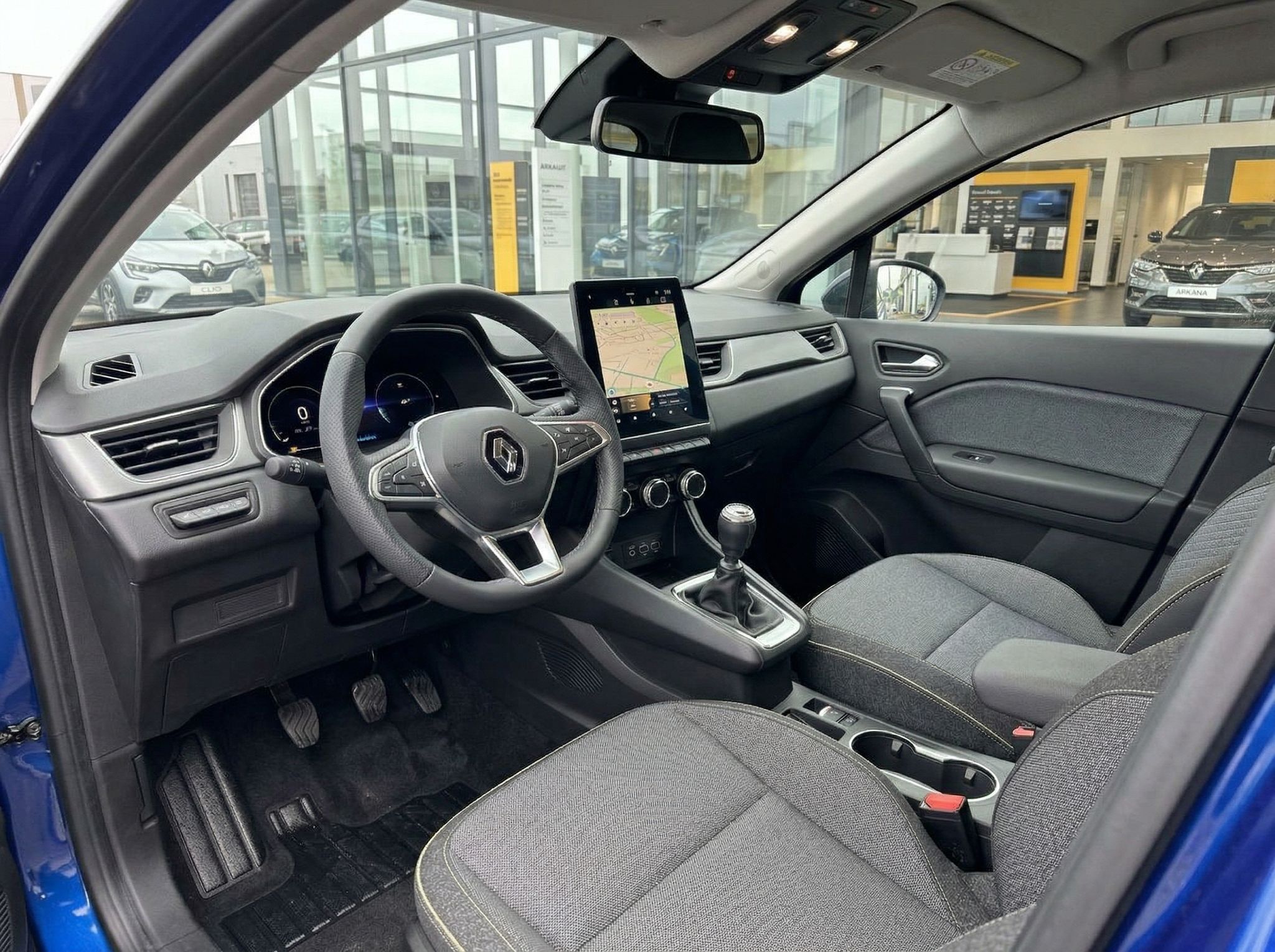 Renault Captur Innenraum - Cockpit mit Navigationssystem, Lenkrad und grauen Stoffsitzen
