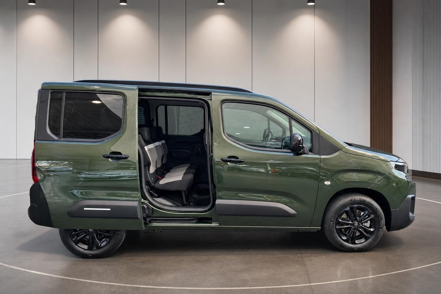 Grüner Citroën Berlingo mit offener Schiebetür - Einblick in den Fahrgastraum und Sitze