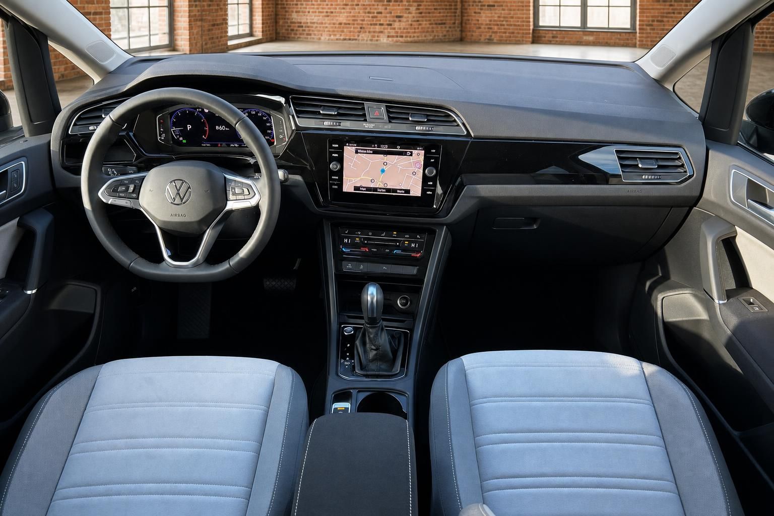 VW Cockpit Frontansicht mit Lenkrad, Navi und blauen Vordersitzen
