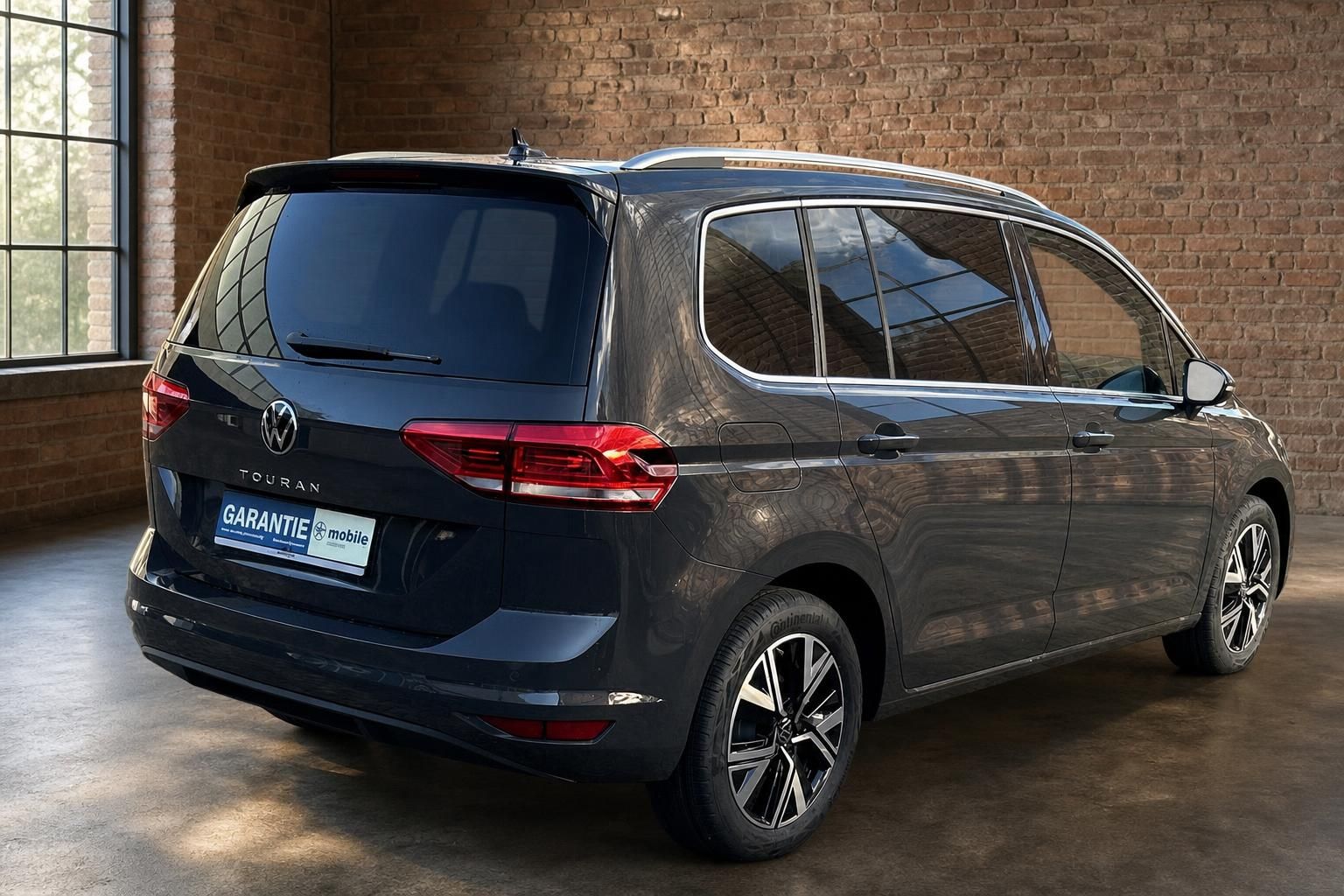 VW Touran dunkelgrau Heckansicht seitlich mit Alufelgen