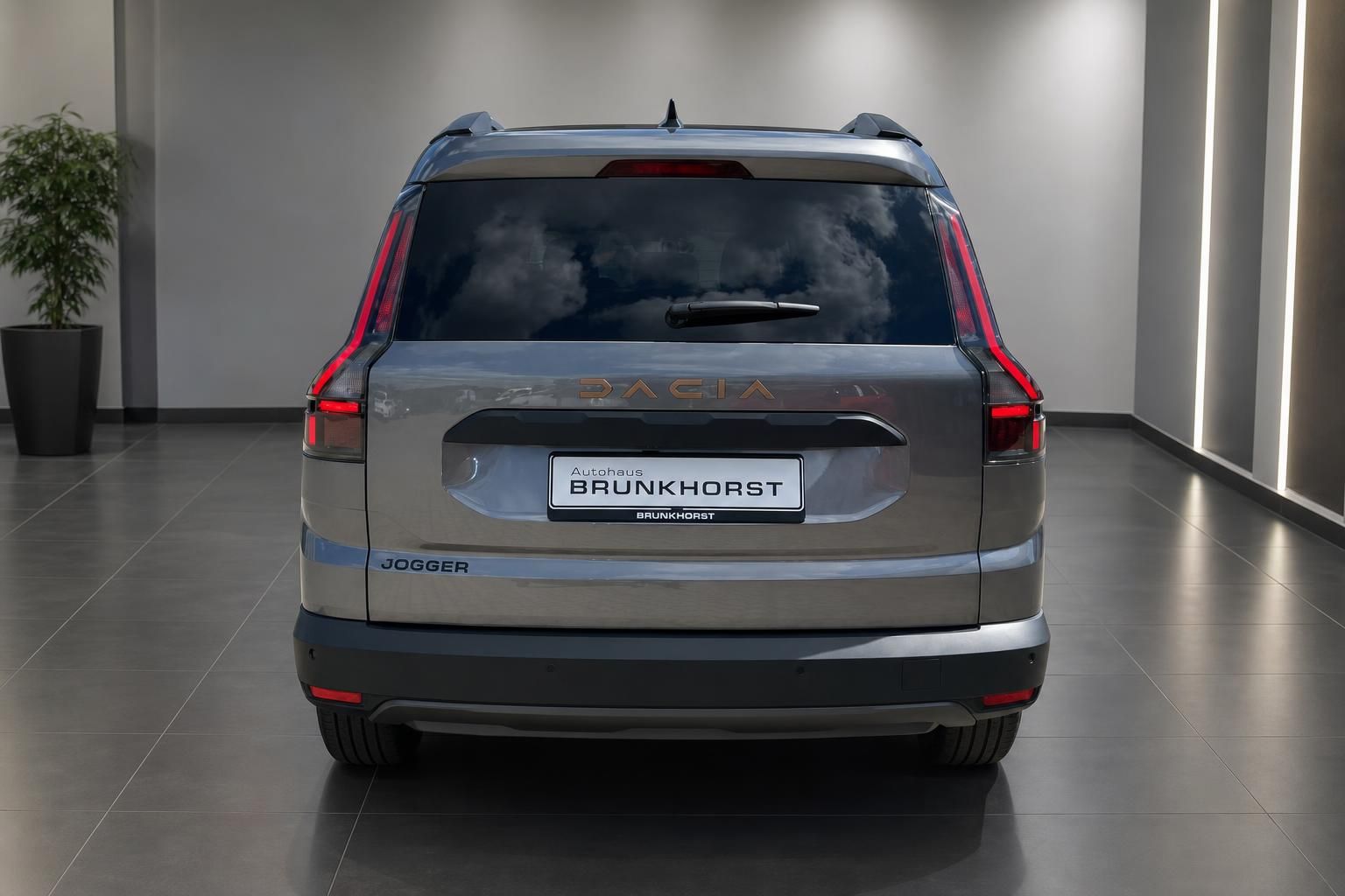 Dacia Jogger Heckansicht in Grau mit Kennzeichen Autohaus Brunkhorst im modernen Showroom