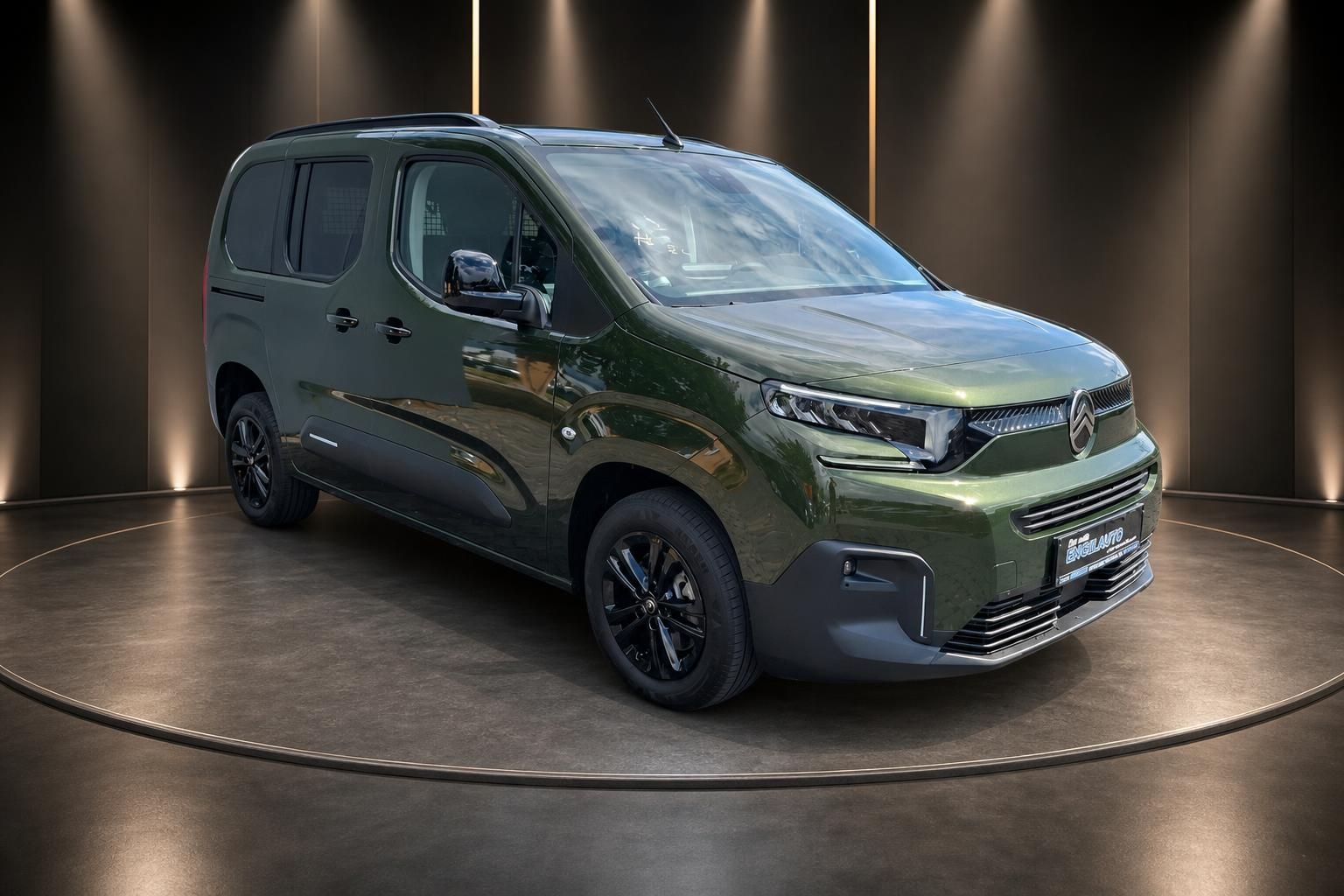 Citroen Berlingo grün metallic Schrägansicht von vorn links auf Drehscheibe im Studio