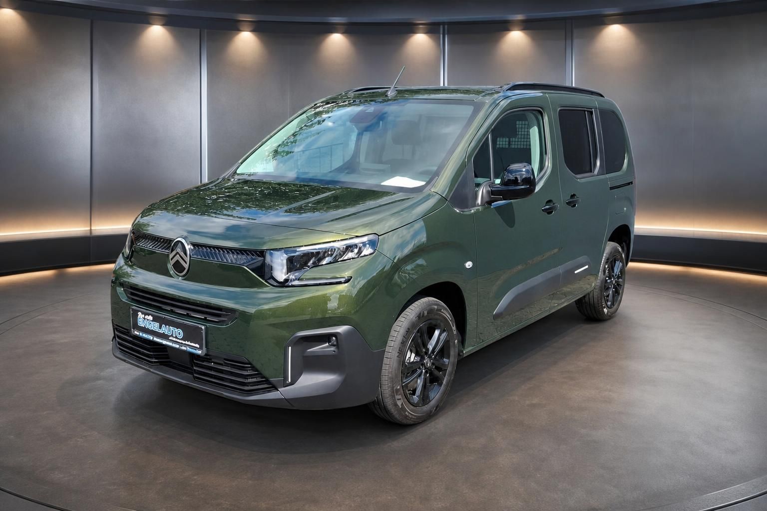 Citroen Berlingo grün metallic Transporter Frontansicht mit schwarzen Felgen im Autohaus Showroom