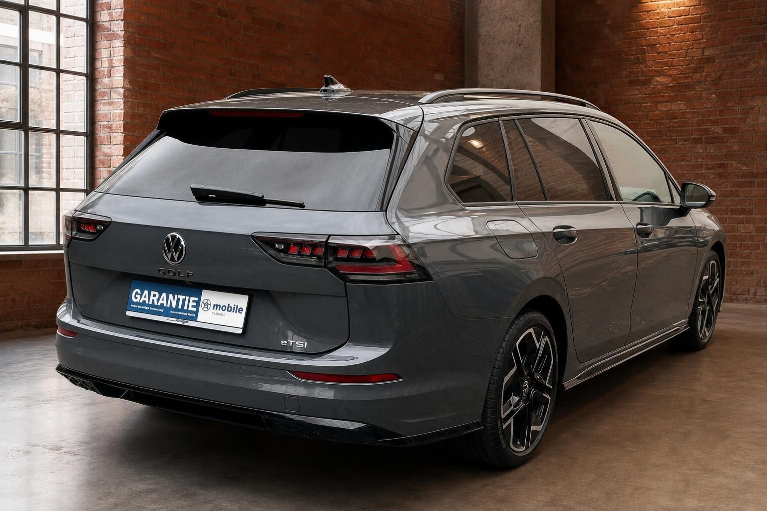 VW Golf Variant eTSI grau, Heck-Seitenansicht im Industrieloft