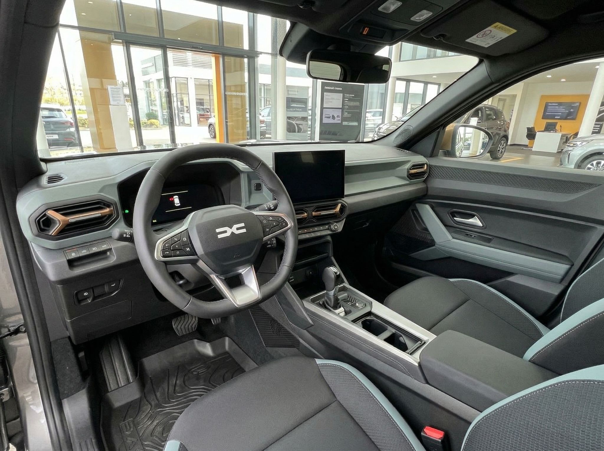 Moderner Dacia Innenraum mit schwarzem Cockpit, Touchscreen und sportlichen Sitzen