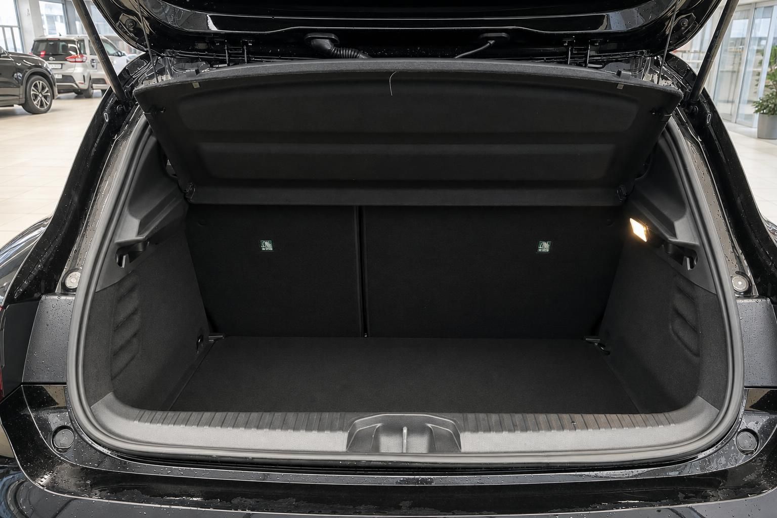 Geöffneter Kofferraum eines schwarzen Fahrzeugs mit umgeklappten Rücksitzen im Autohaus
