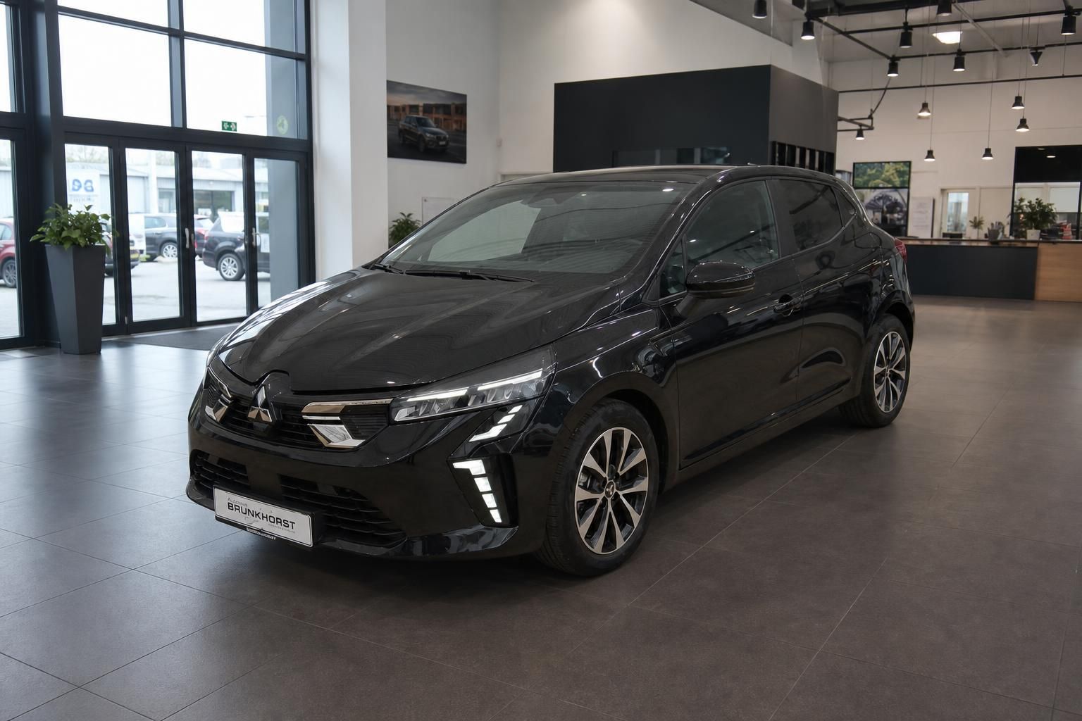Schwarzer Mitsubishi im modernen Autohaus-Showroom mit LED-Beleuchtung und großen Fenstern