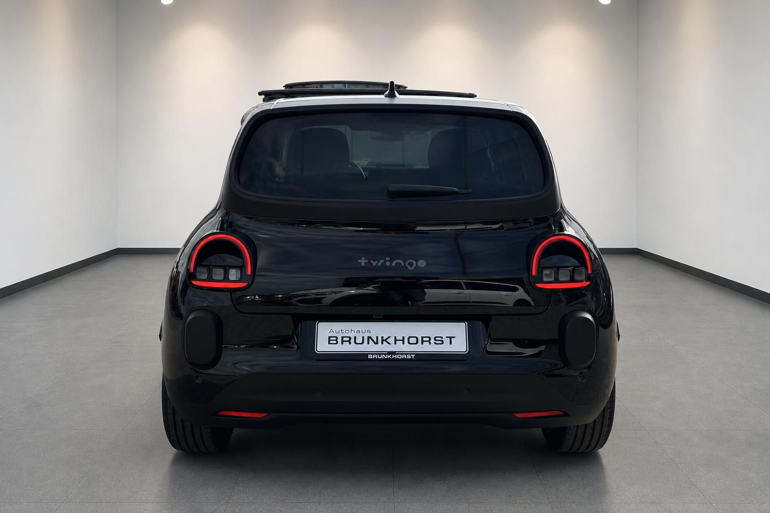 Renault Twingo Elektro Heckansicht in schwarz mit roten Rücklichtern im Autohaus Brunkhorst Showroom
