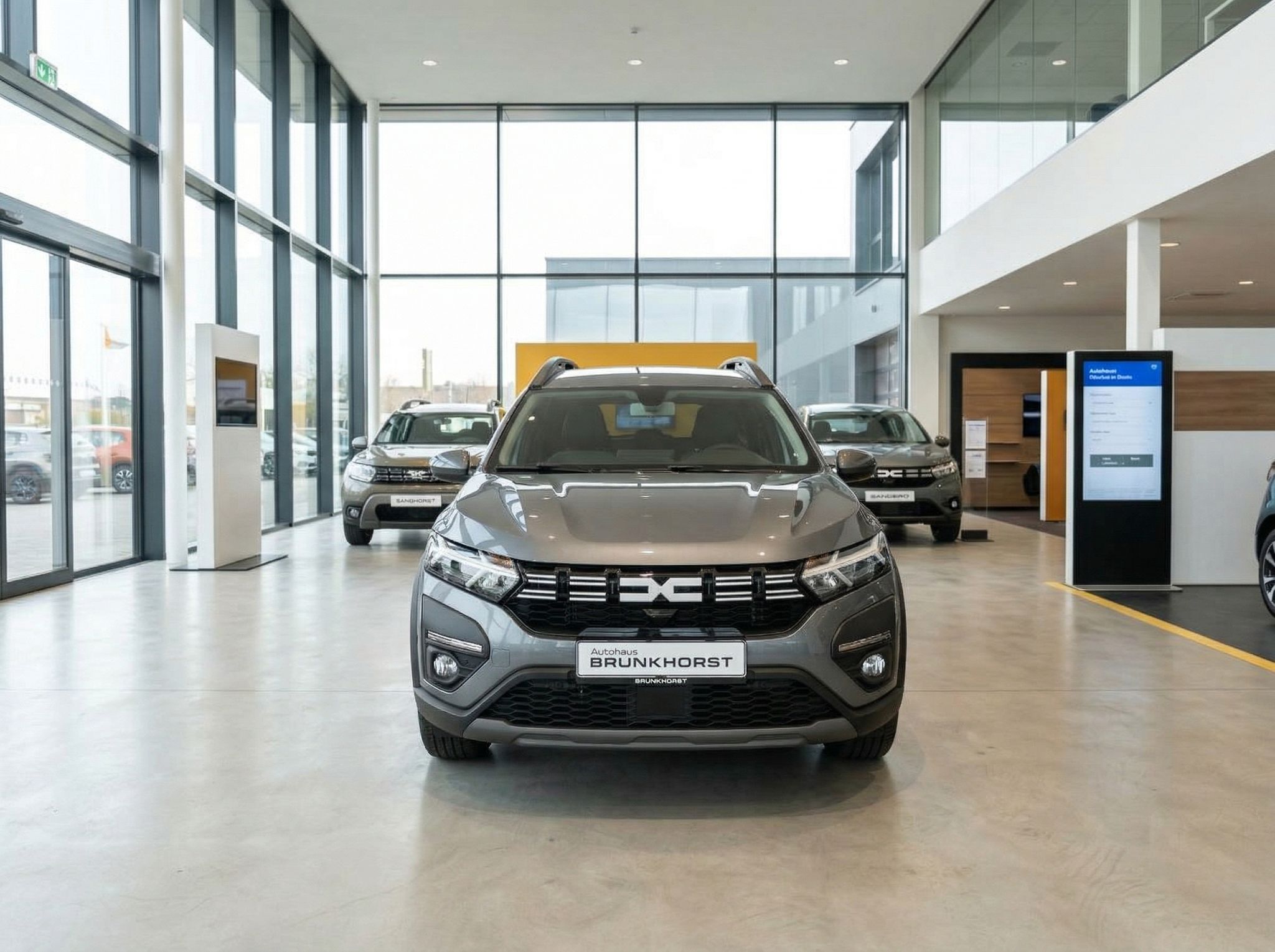 Dacia SUV grau metallic Frontansicht im modernen Autohaus Showroom