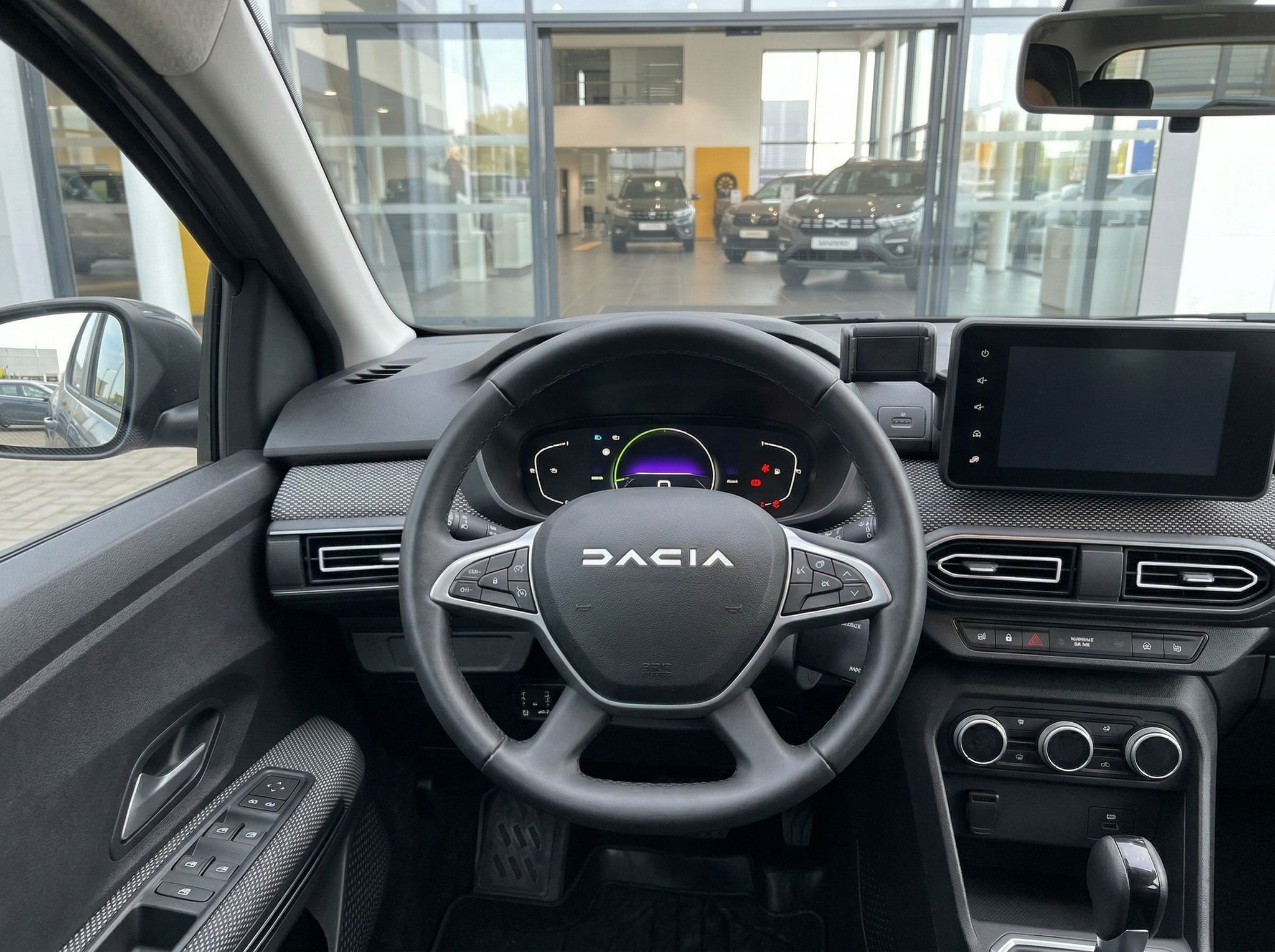 Dacia Fahrerplatz mit Lenkrad, Tacho und digitalem Display - Innenansicht