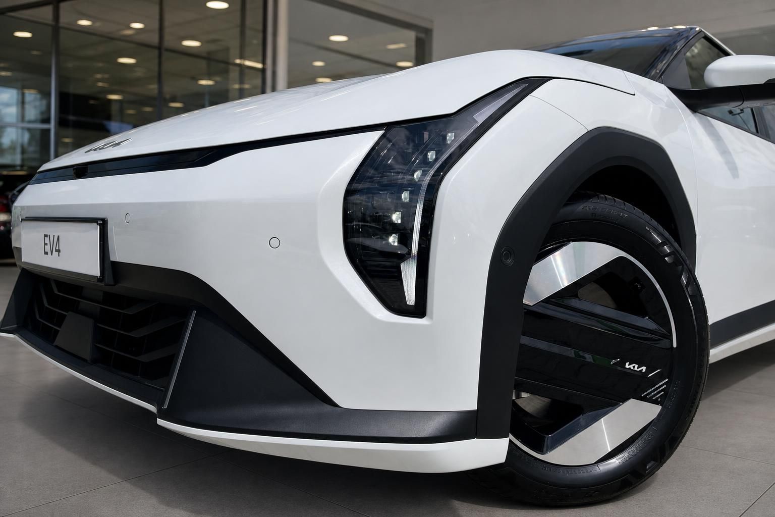 Kia EV4 weiß Frontpartie mit LED-Scheinwerfer und Felge im Detail
