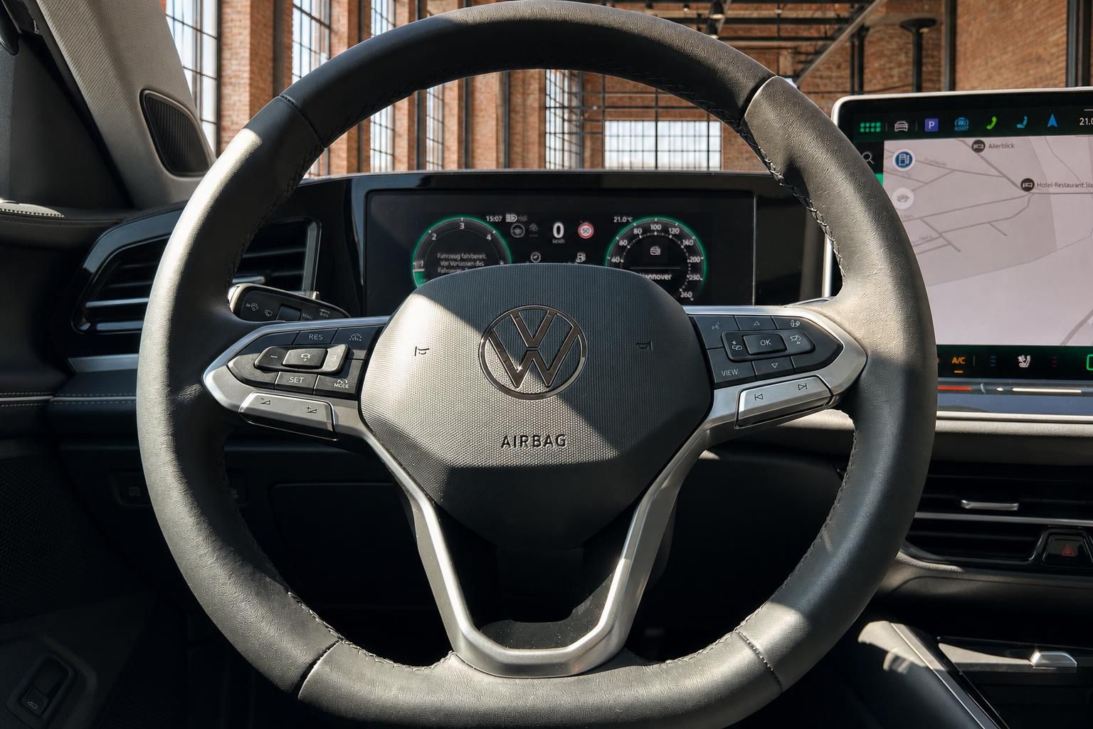 VW Lenkrad Nahaufnahme mit Logo, Tacho und Navigationsbildschirm
