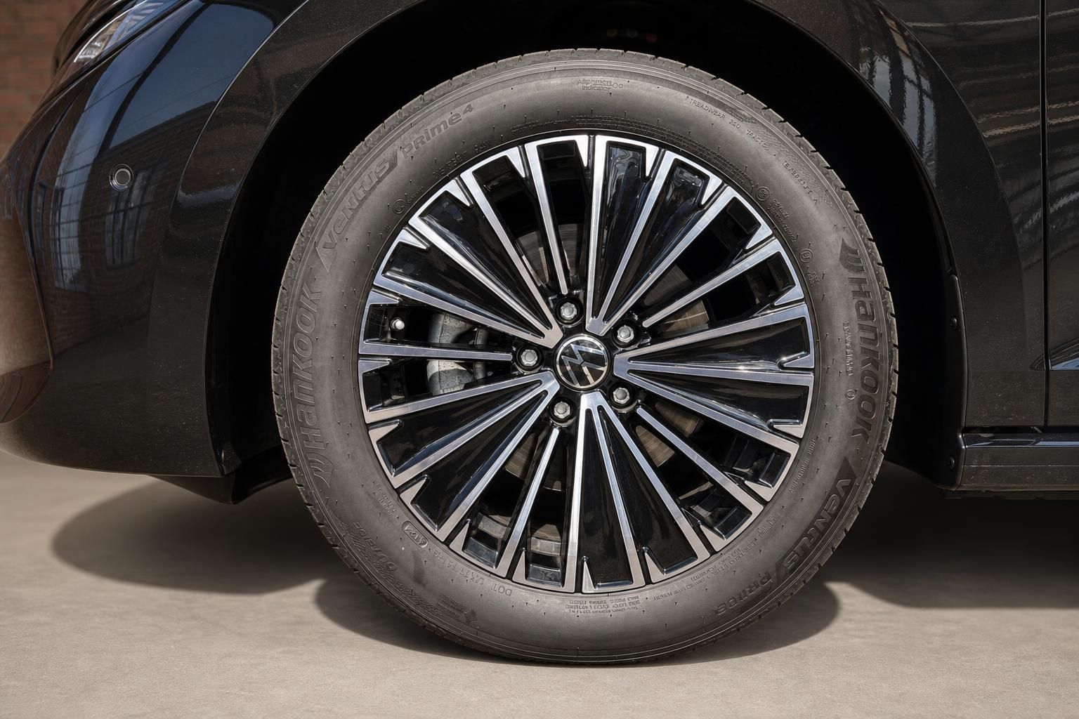 Detailansicht Leichtmetallfelge und Reifen eines schwarzen VW