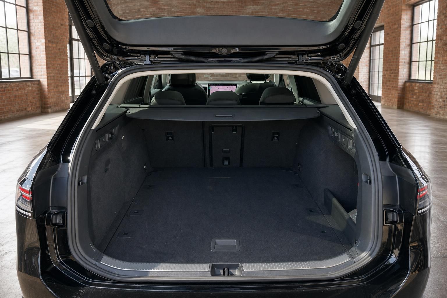 Kofferraum eines schwarzen VW Kombis mit geöffneter Heckklappe