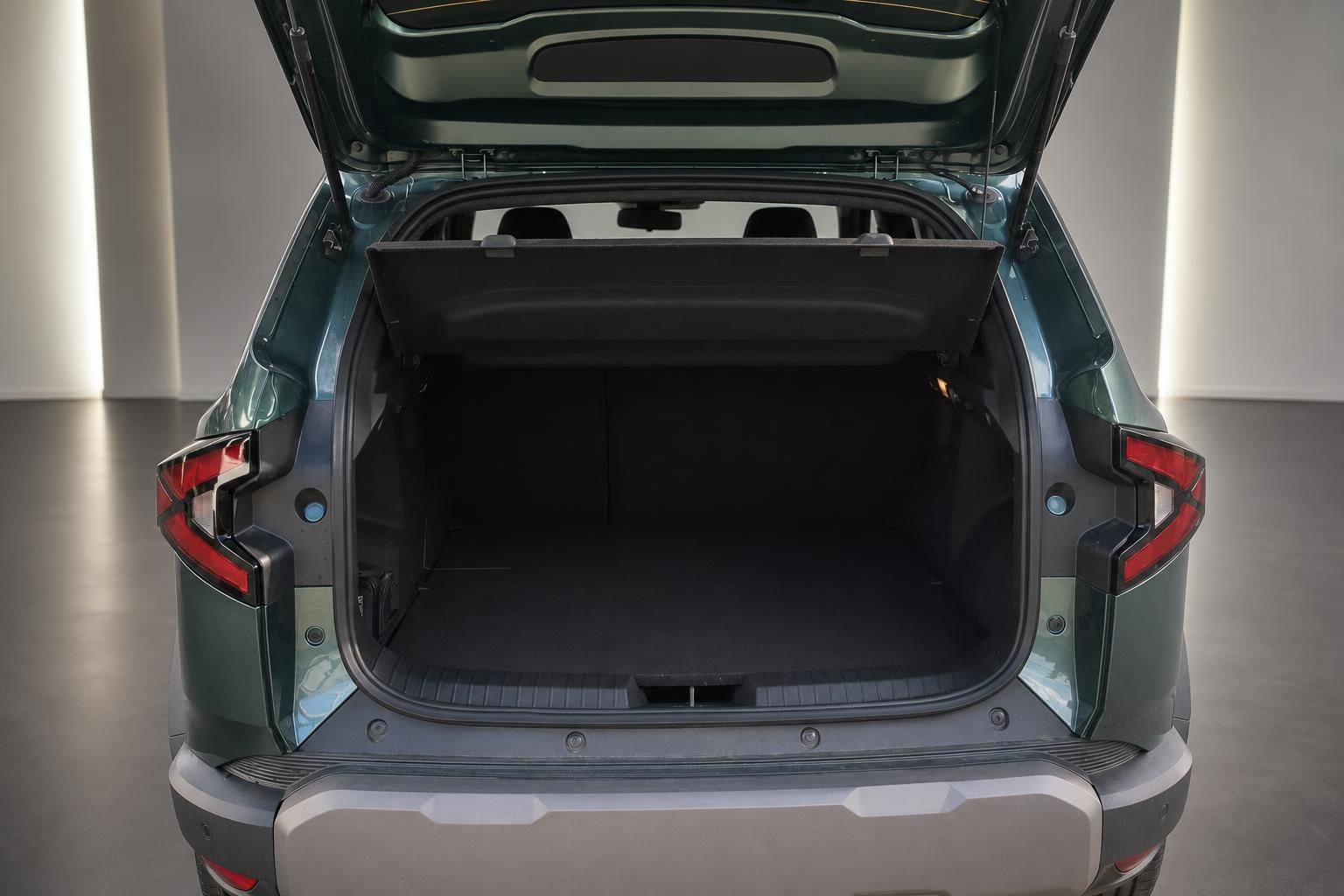 Geöffneter Kofferraum eines grünen SUV mit schwarzer Laderaumauskleidung und großem Stauvolumen