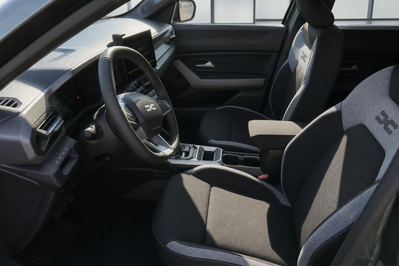 Dacia Fahrzeug Innenraum mit schwarzen Sitzen und modernem Cockpit